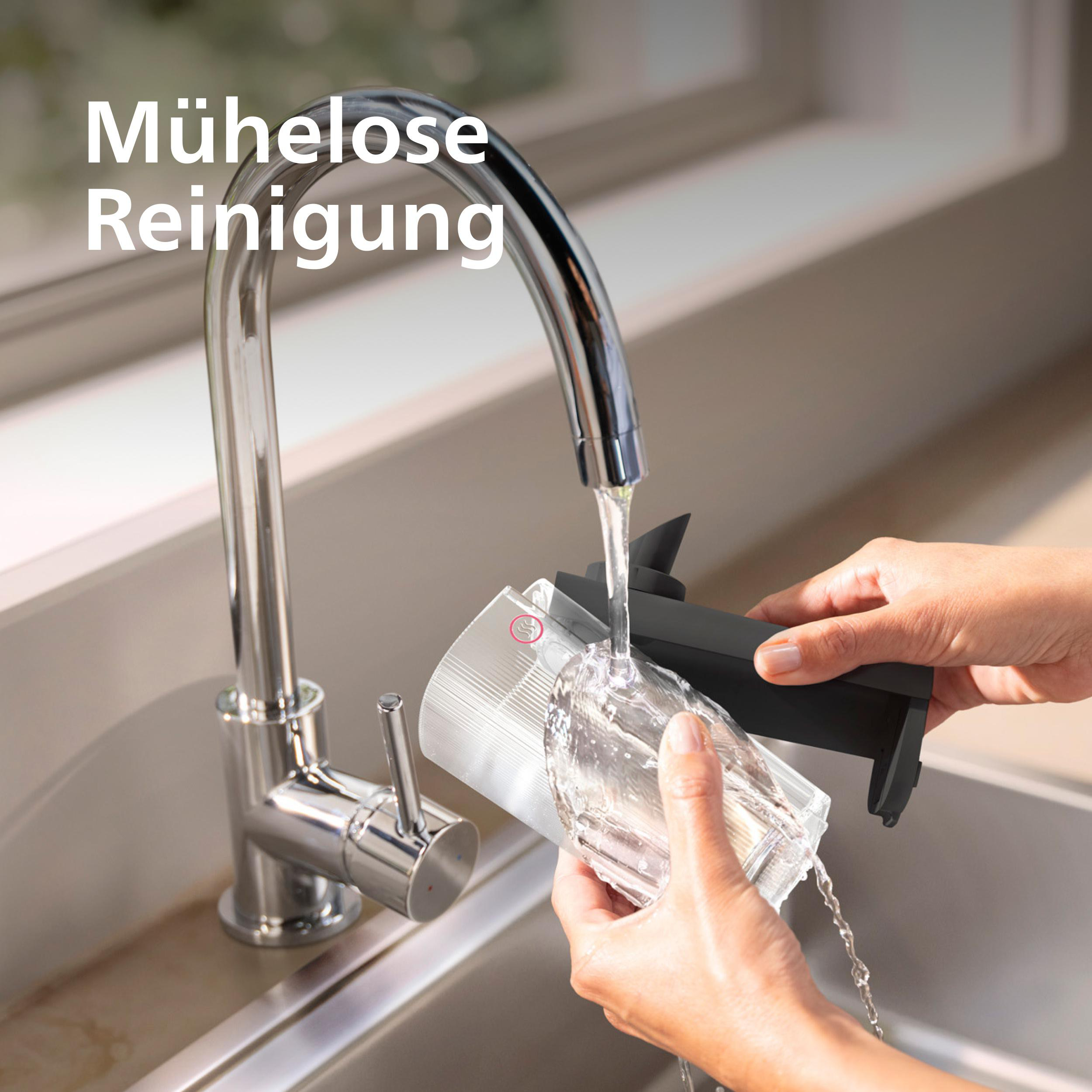 Wasser fließt aus einem Wasserhahn in ein Glas, das von einer Hand gehalten wird.