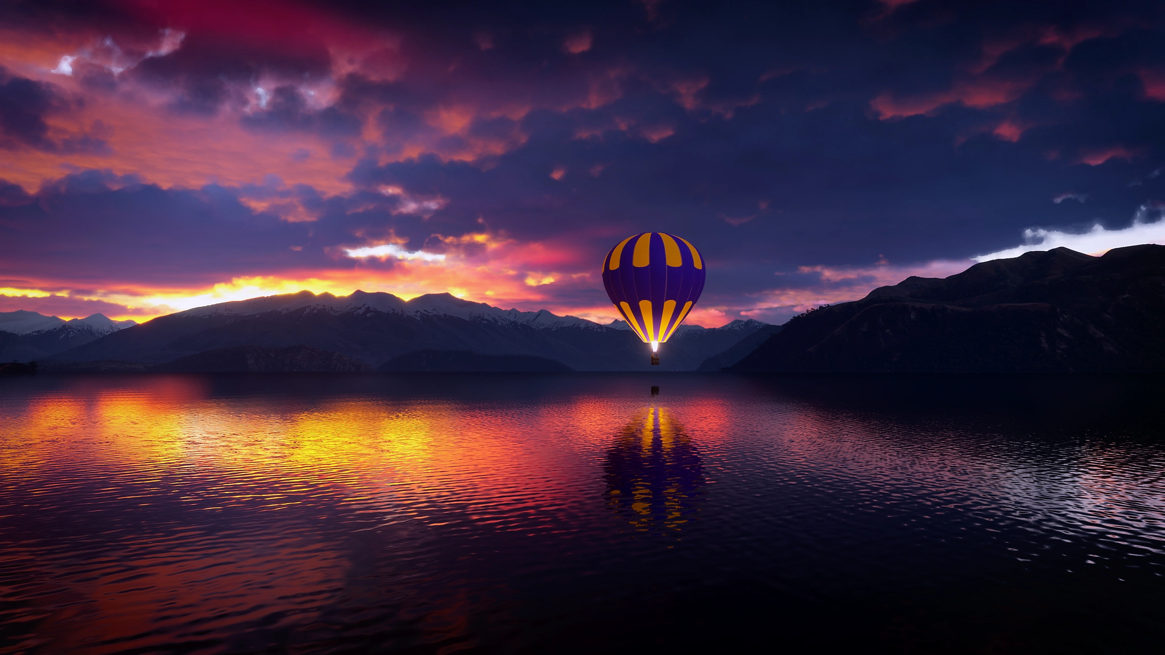 Une montgolfière flotte sur un lac au coucher du soleil avec des montagnes en arrière-plan.