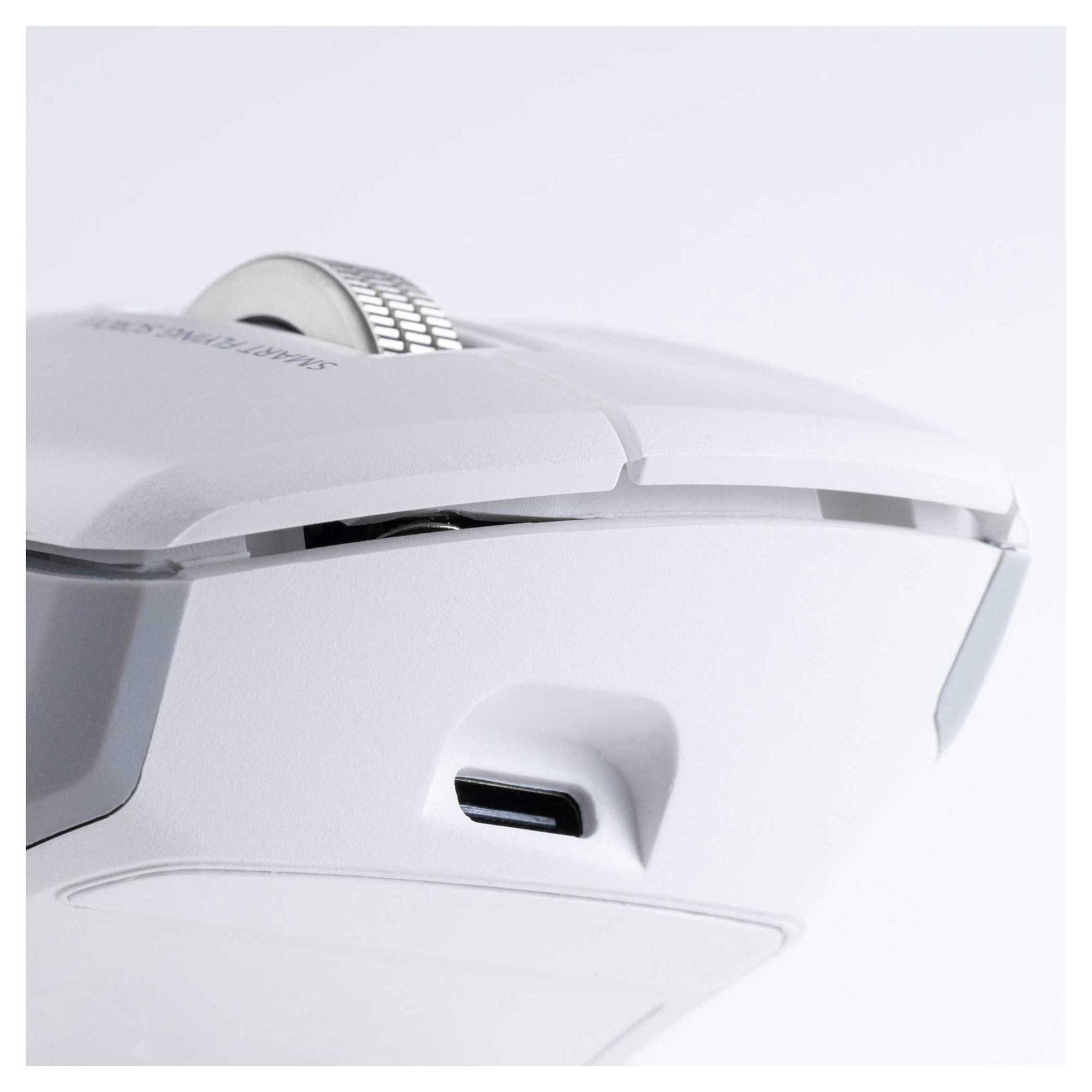 Fehér számítógépes egér közelképe USB-C porttal és recézett görgővel.
