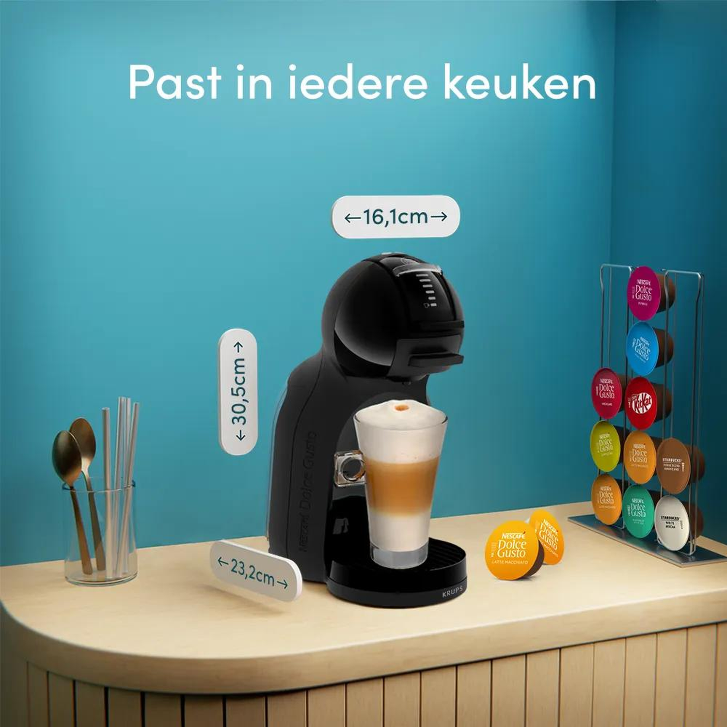 Coffee machine with coffee and pods on a table. Dimensions are shown.
