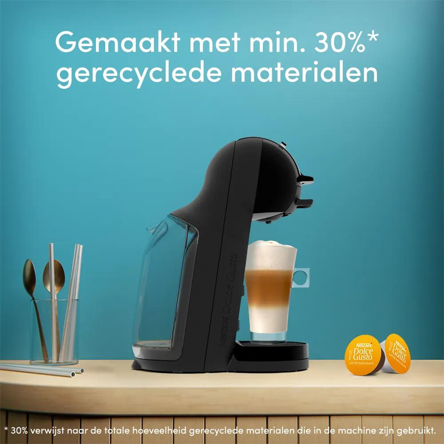 A black coffee machine with a latte macchiato and capsules.