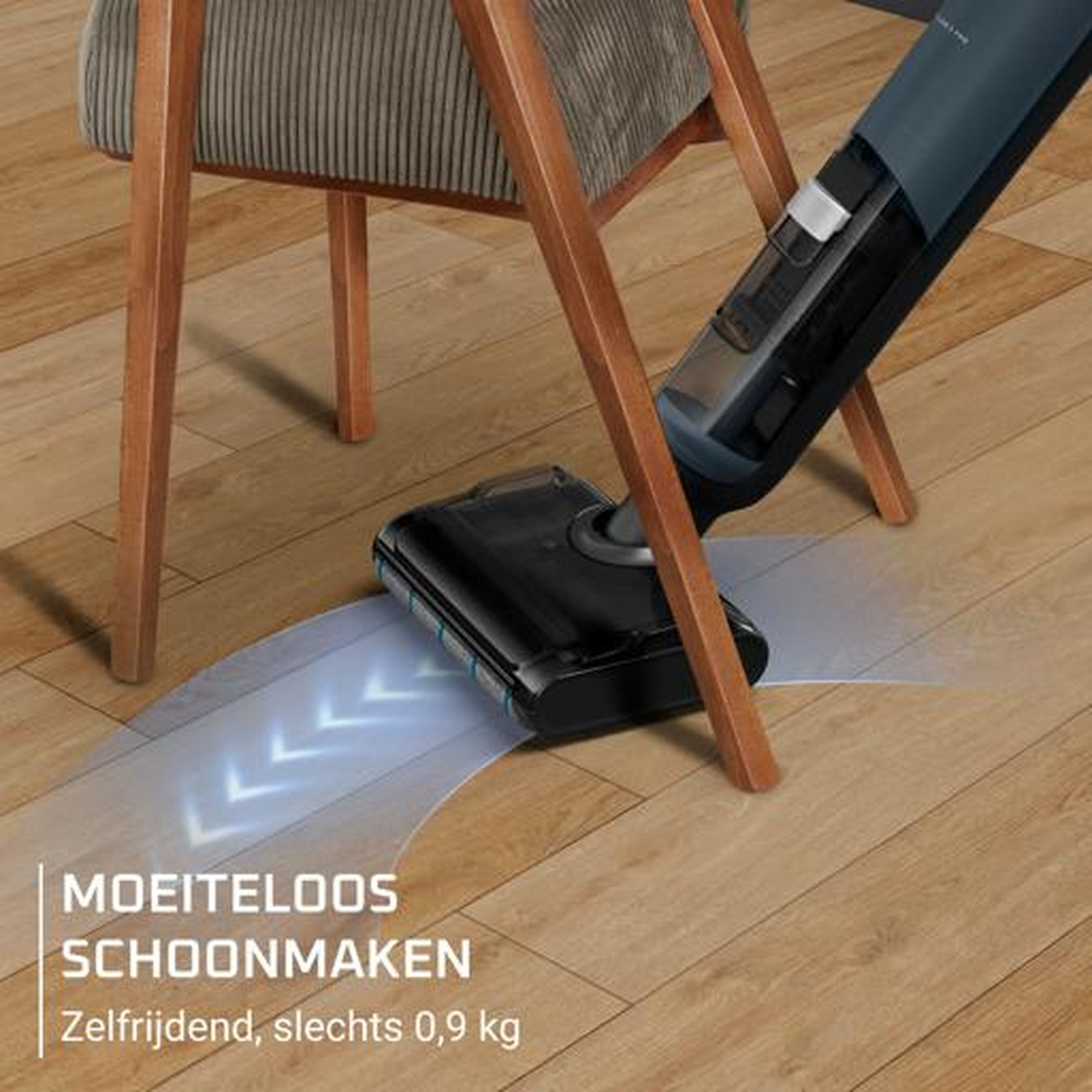 A blue cordless vacuum cleans a wooden floor next to a chair.