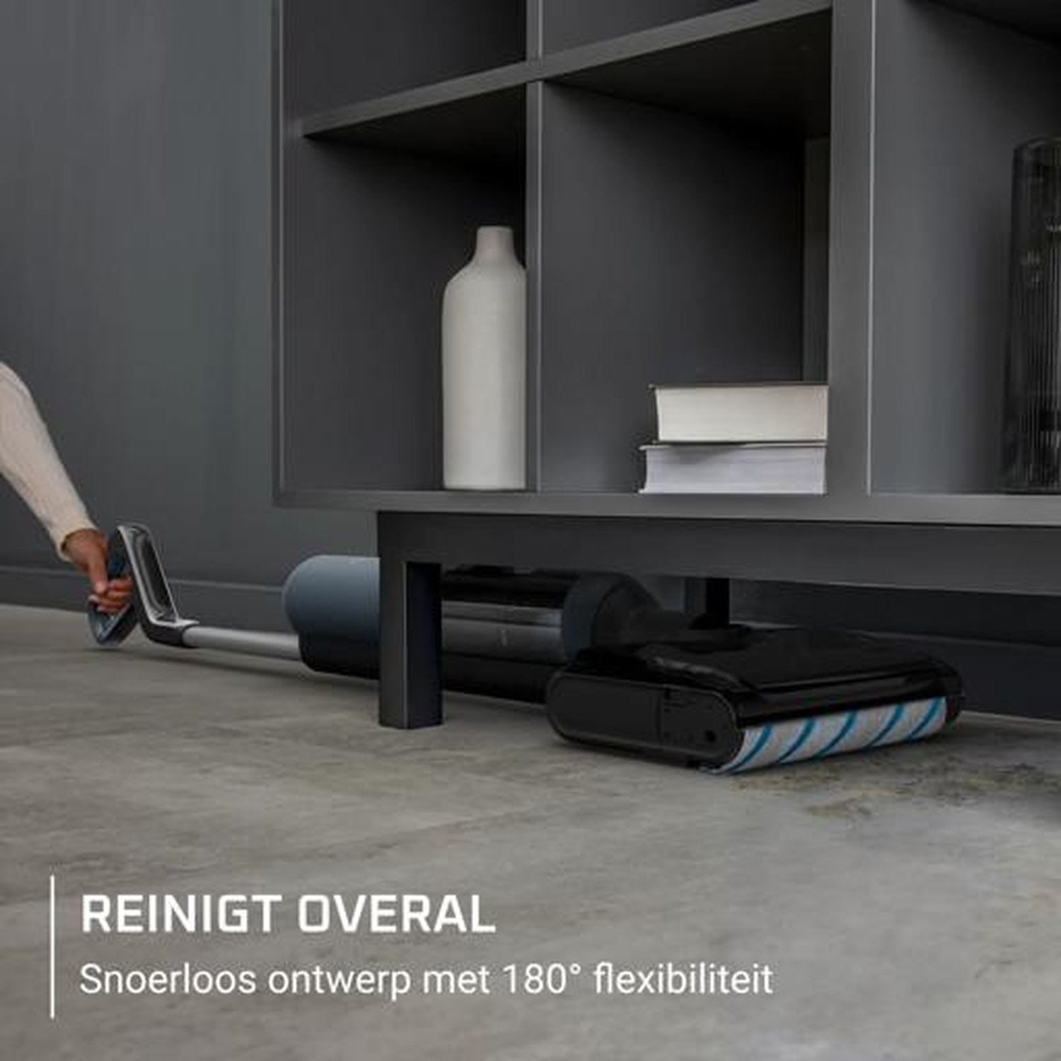 A cordless vacuum with a flexible floor head cleans under a shelf.