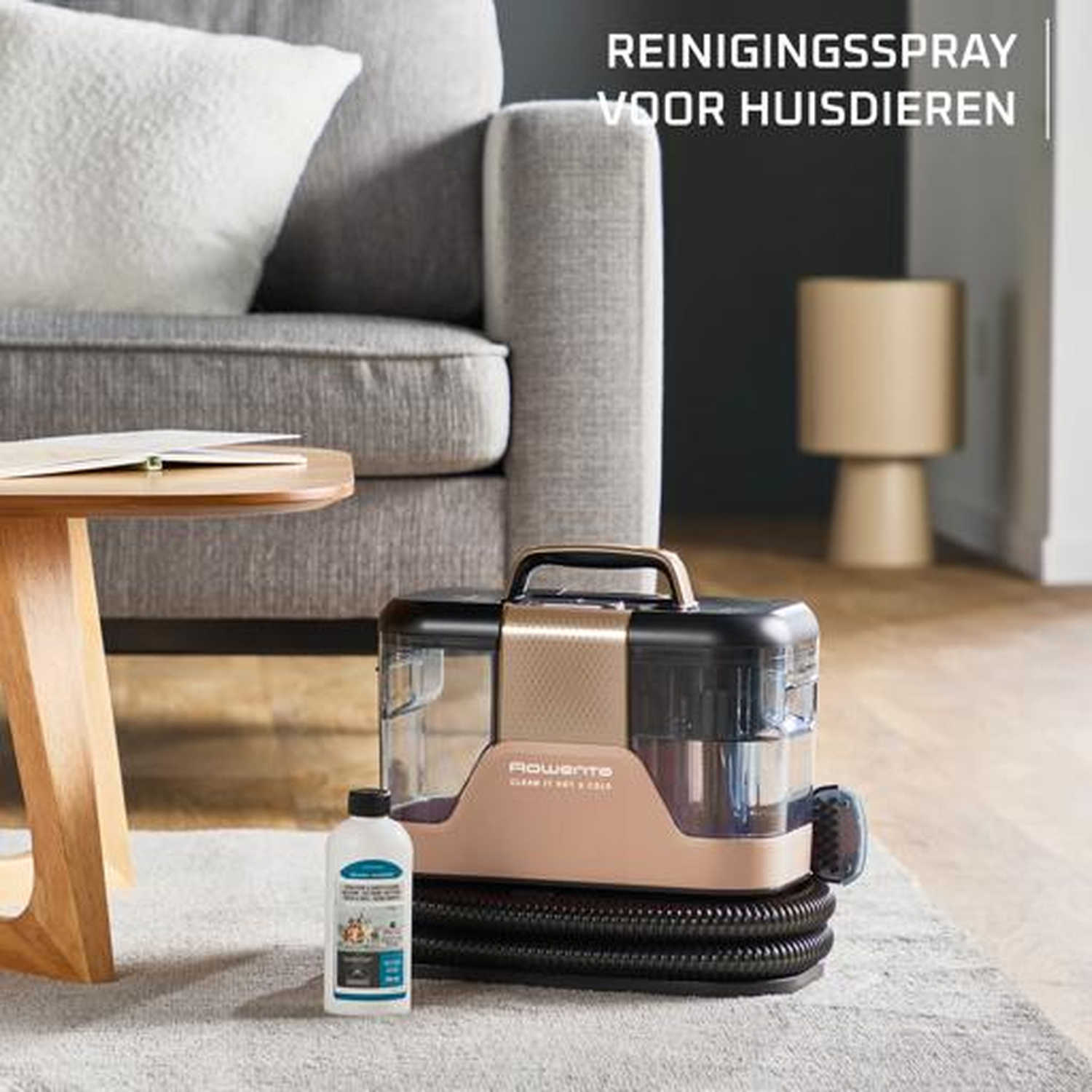 Cleaning device with bottle on rug next to couch. Gold and black colors.