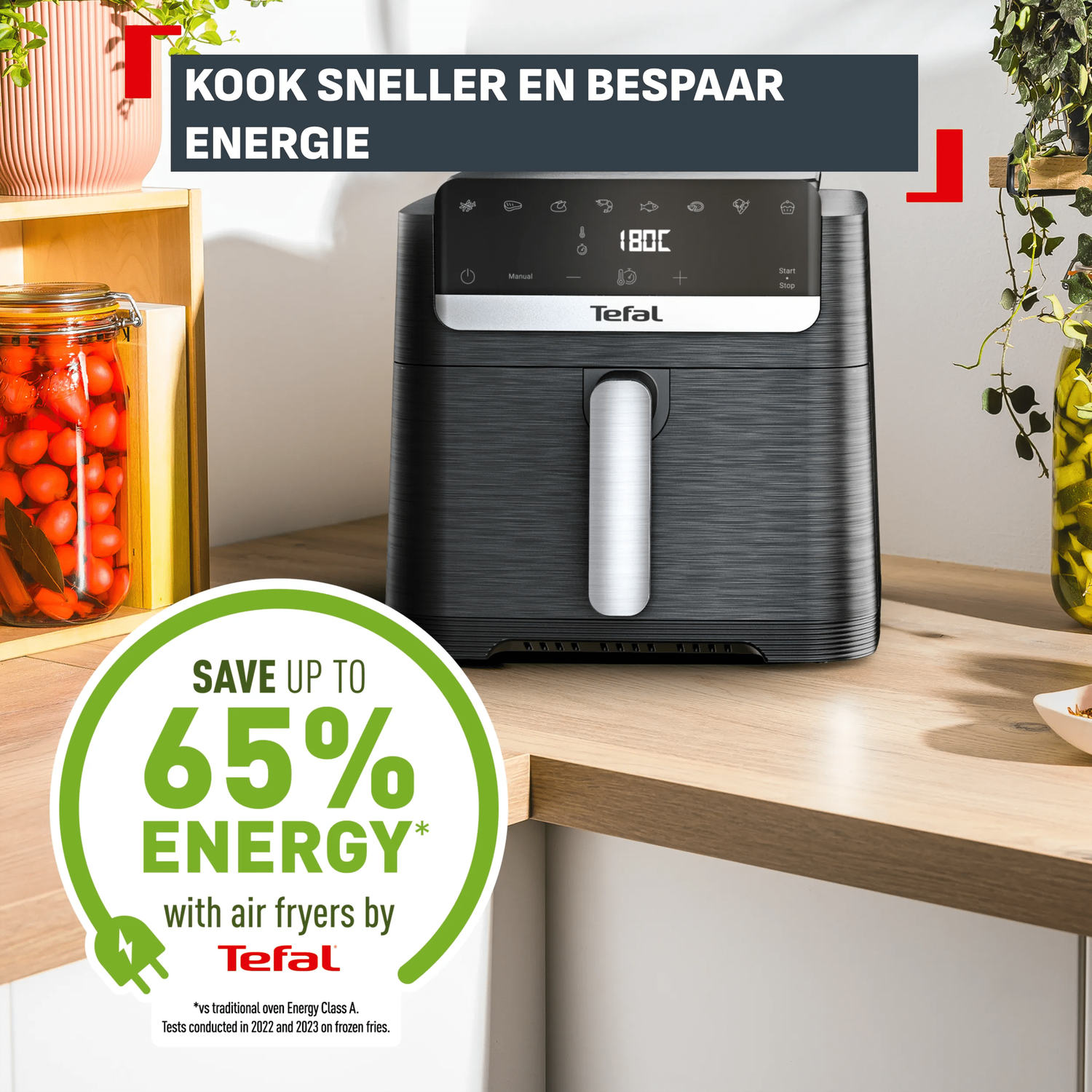 Een zwarte Tefal airfryer staat op een houten aanrecht met potten.