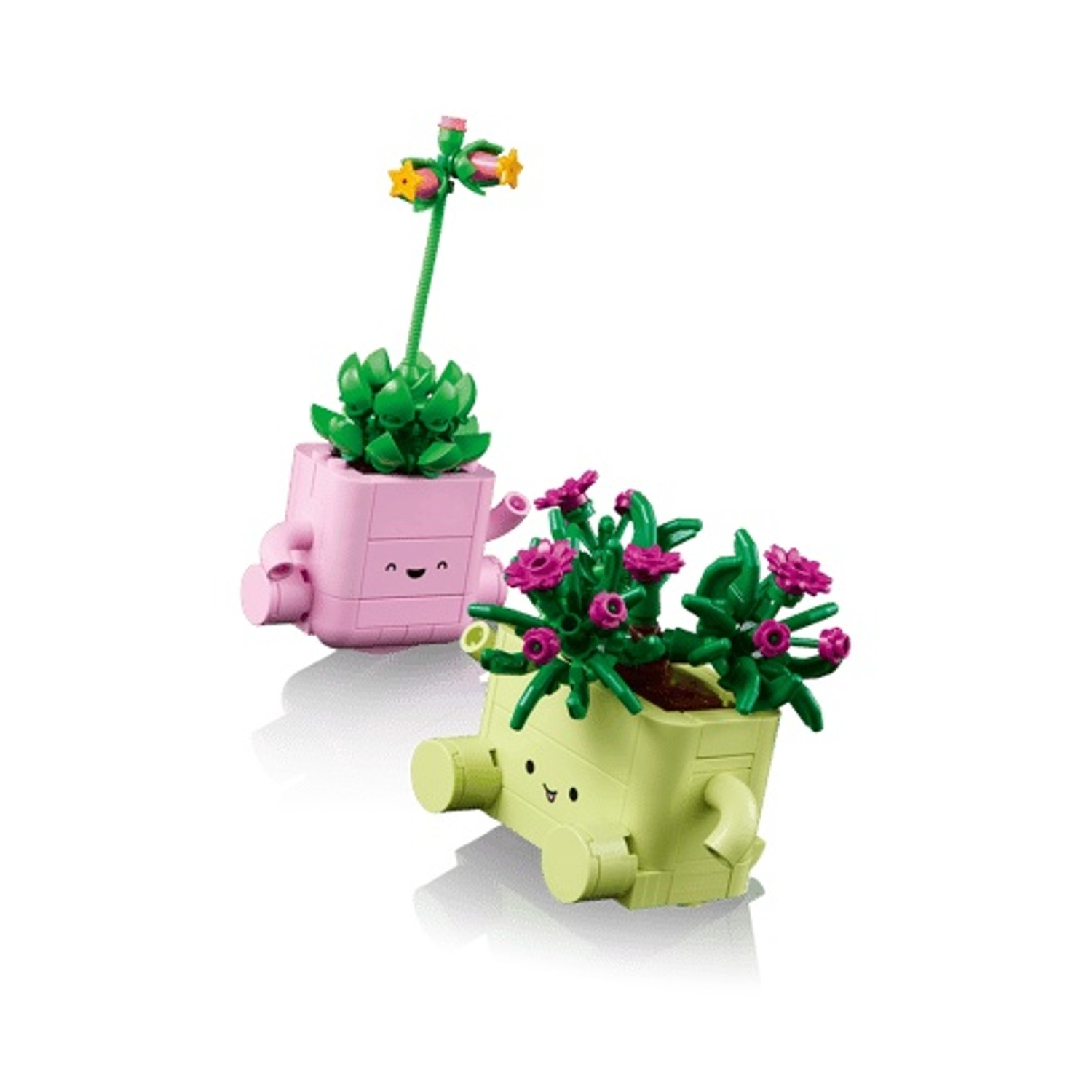 Due vasi di fiori Lego con facce. Uno è rosa con una succulenta, uno è verde chiaro con fiori rosa.