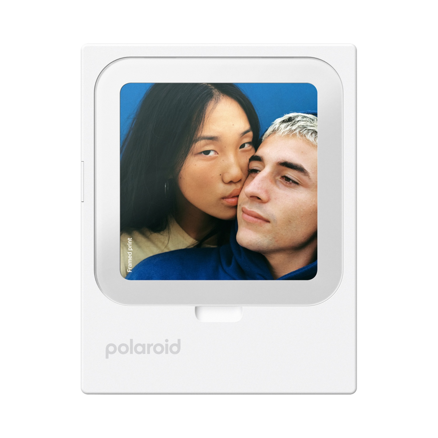 Una coppia si bacia su sfondo blu su una stampa Polaroid.