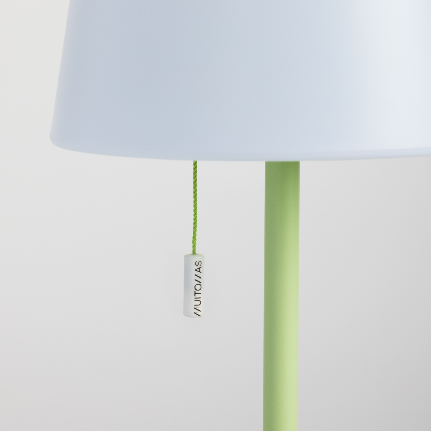 Una lampada con paralume azzurro e stelo verde chiaro.