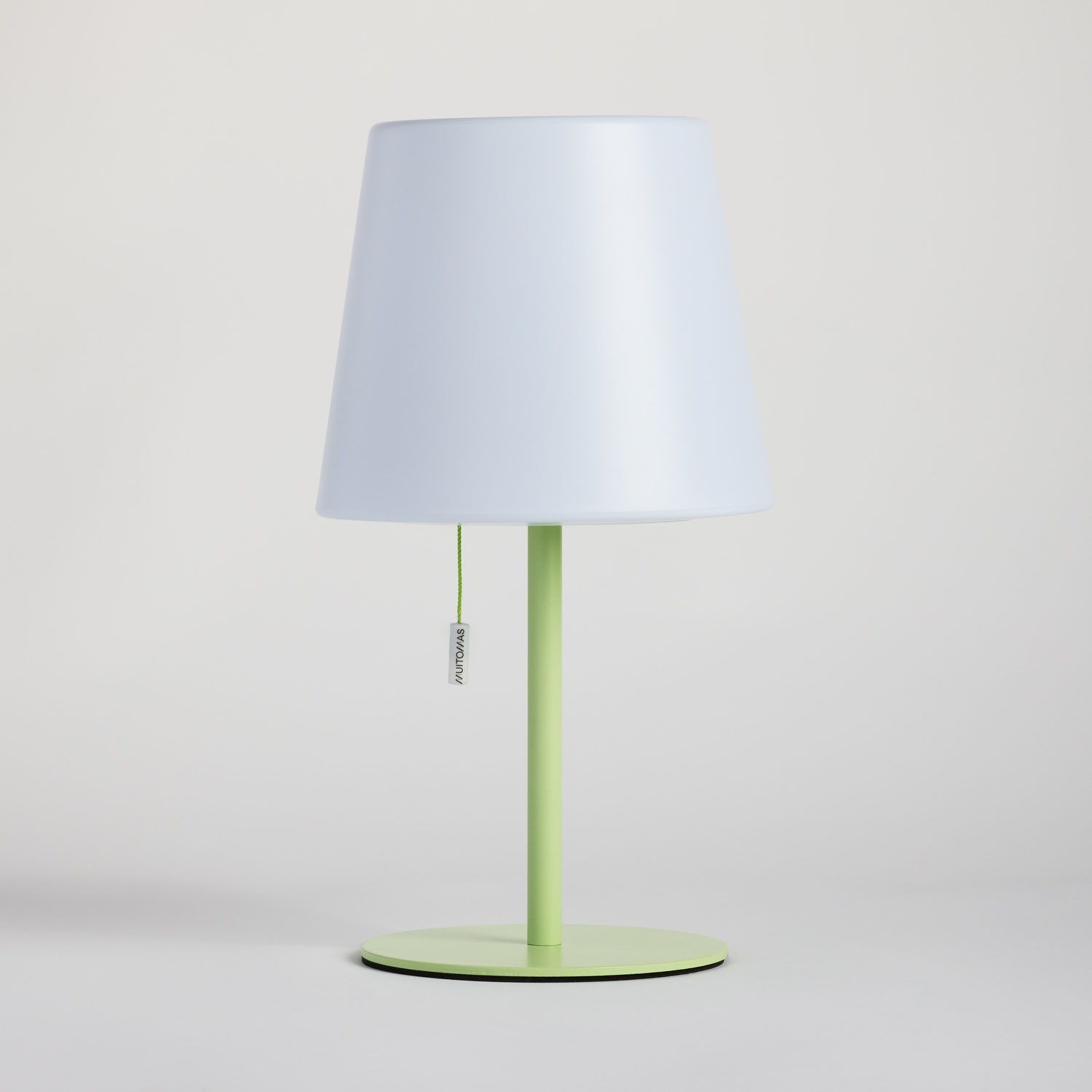 Una lampada bianca con stelo e base verdi su sfondo chiaro.