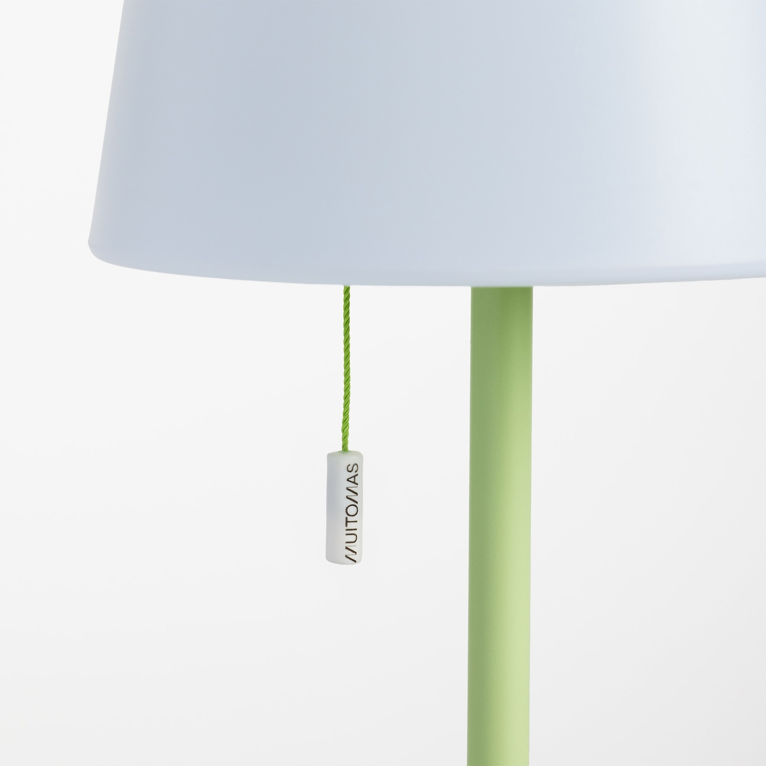 Paralume azzurro con cordicella verde e targhetta bianca con testo.