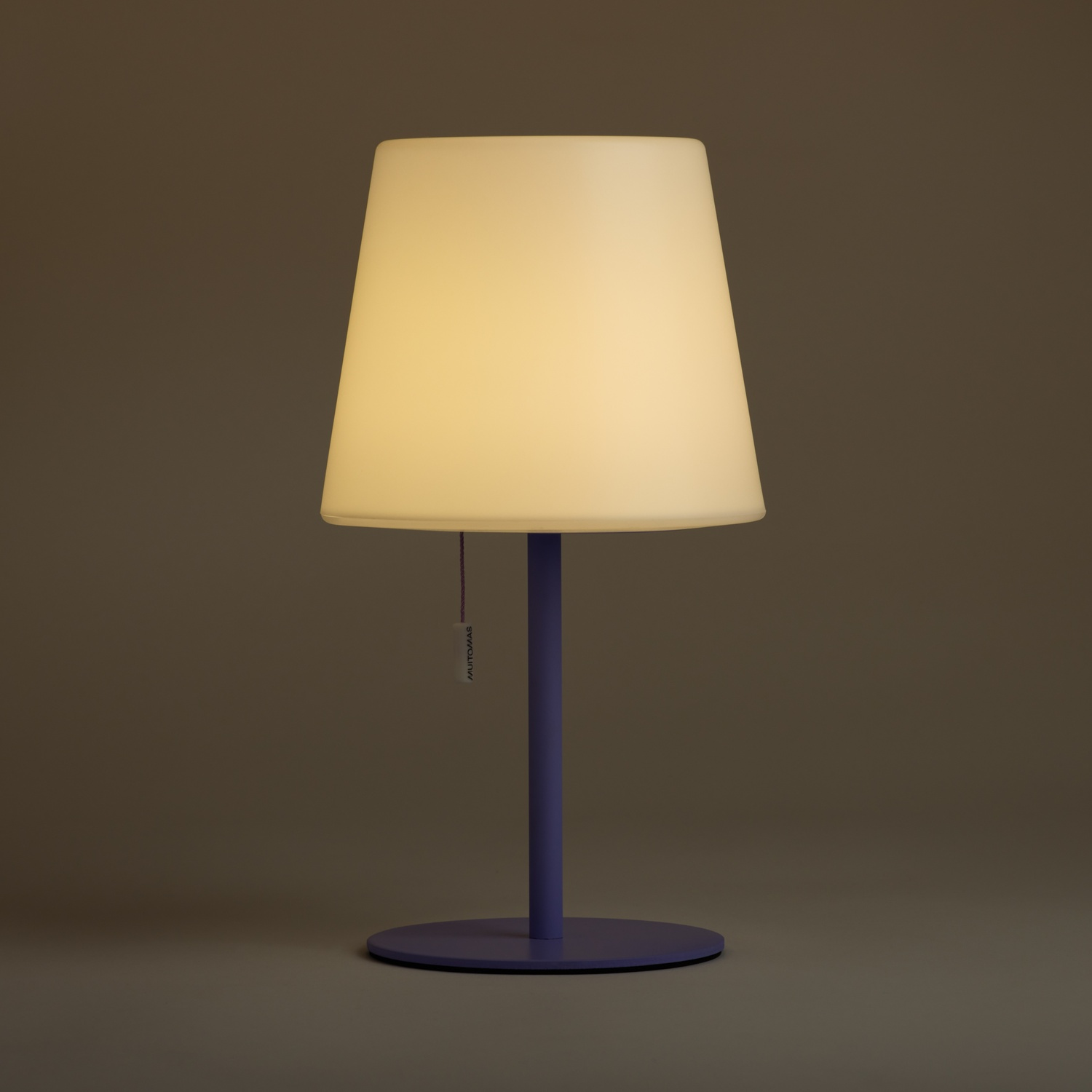 Lampada viola con paralume bianco su sfondo scuro.