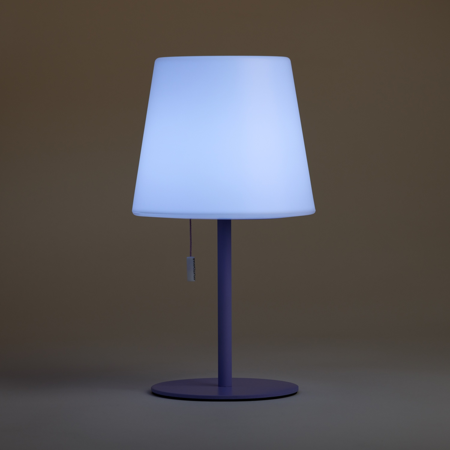 Lampada da terra viola con paralume conico bianco che emette una luce soffusa.