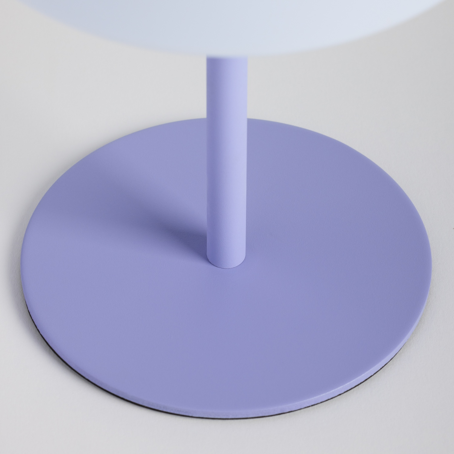 Una base rotonda lavanda con un supporto verticale.