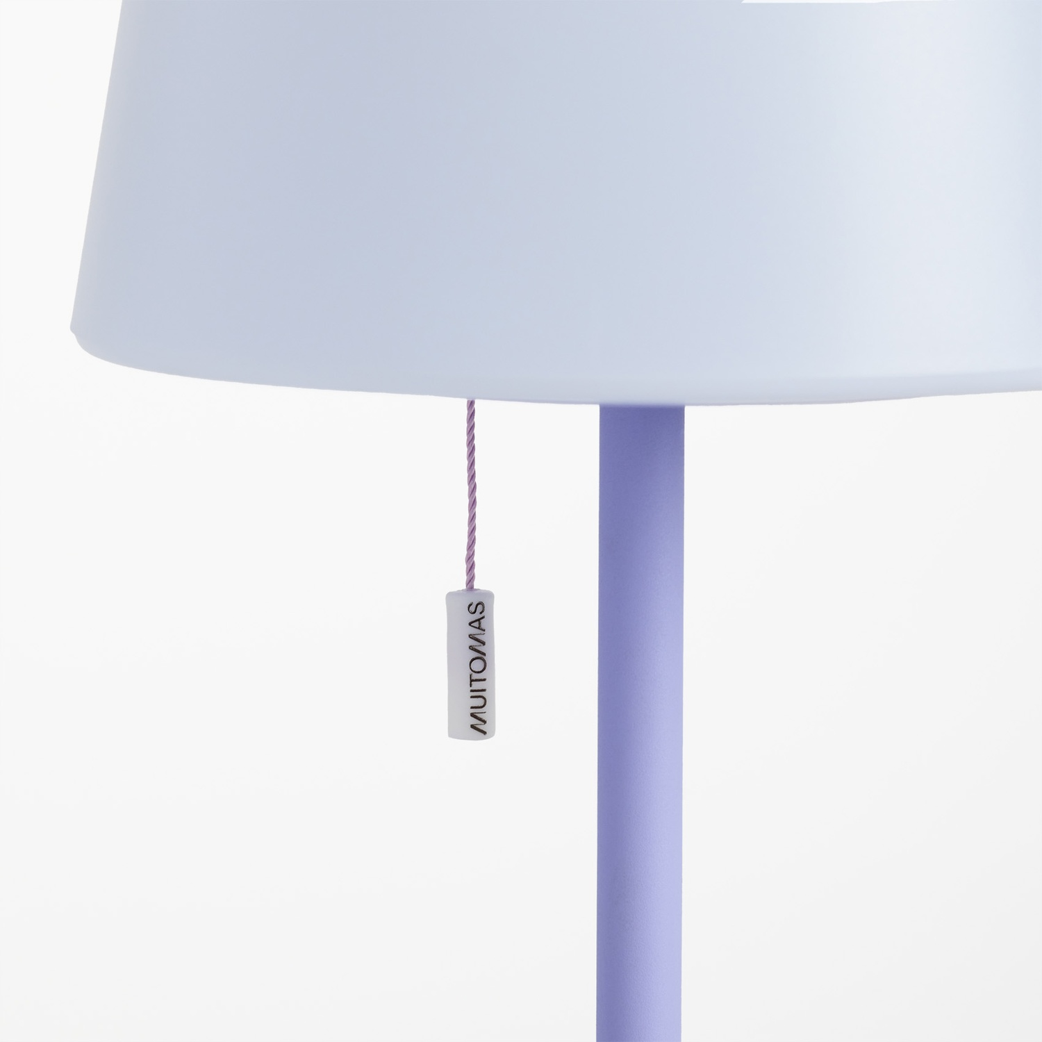 Una lampada lavanda con paralume bianco e cordoncino argentato.