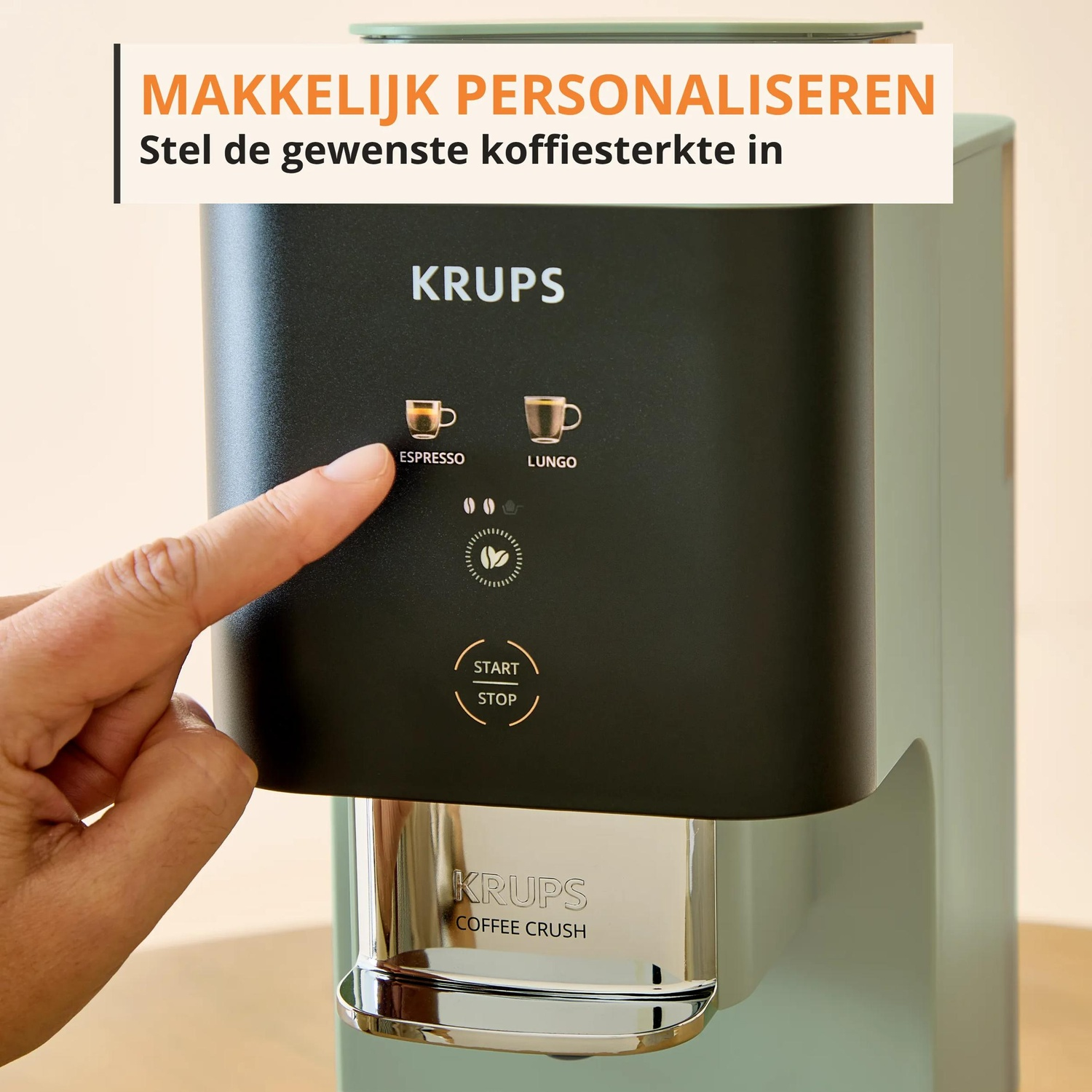 A hand presses the ESPRESSO button on a Krups coffee machine.