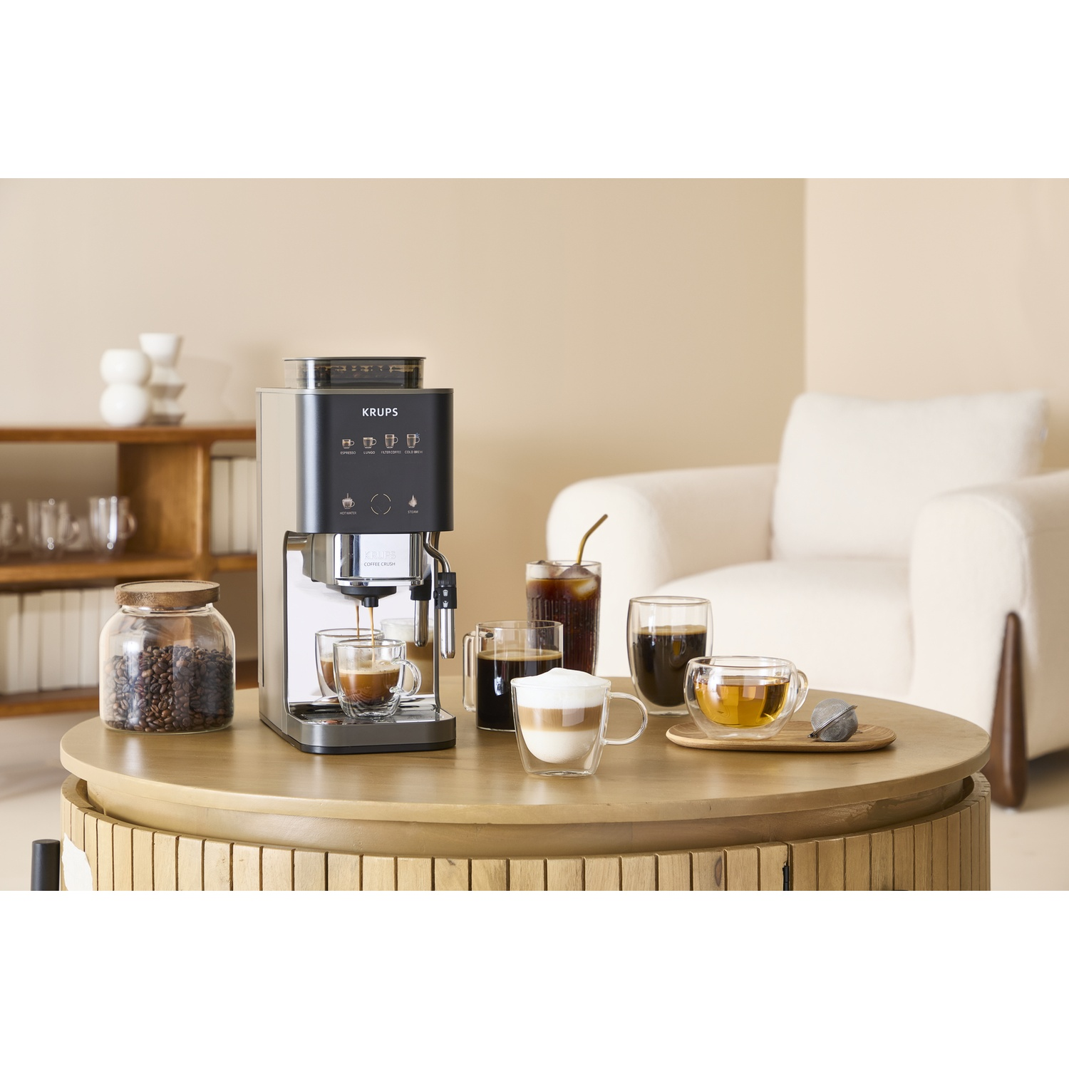 A coffee machine brews espresso into a cup, with coffee and tea drinks beside it.