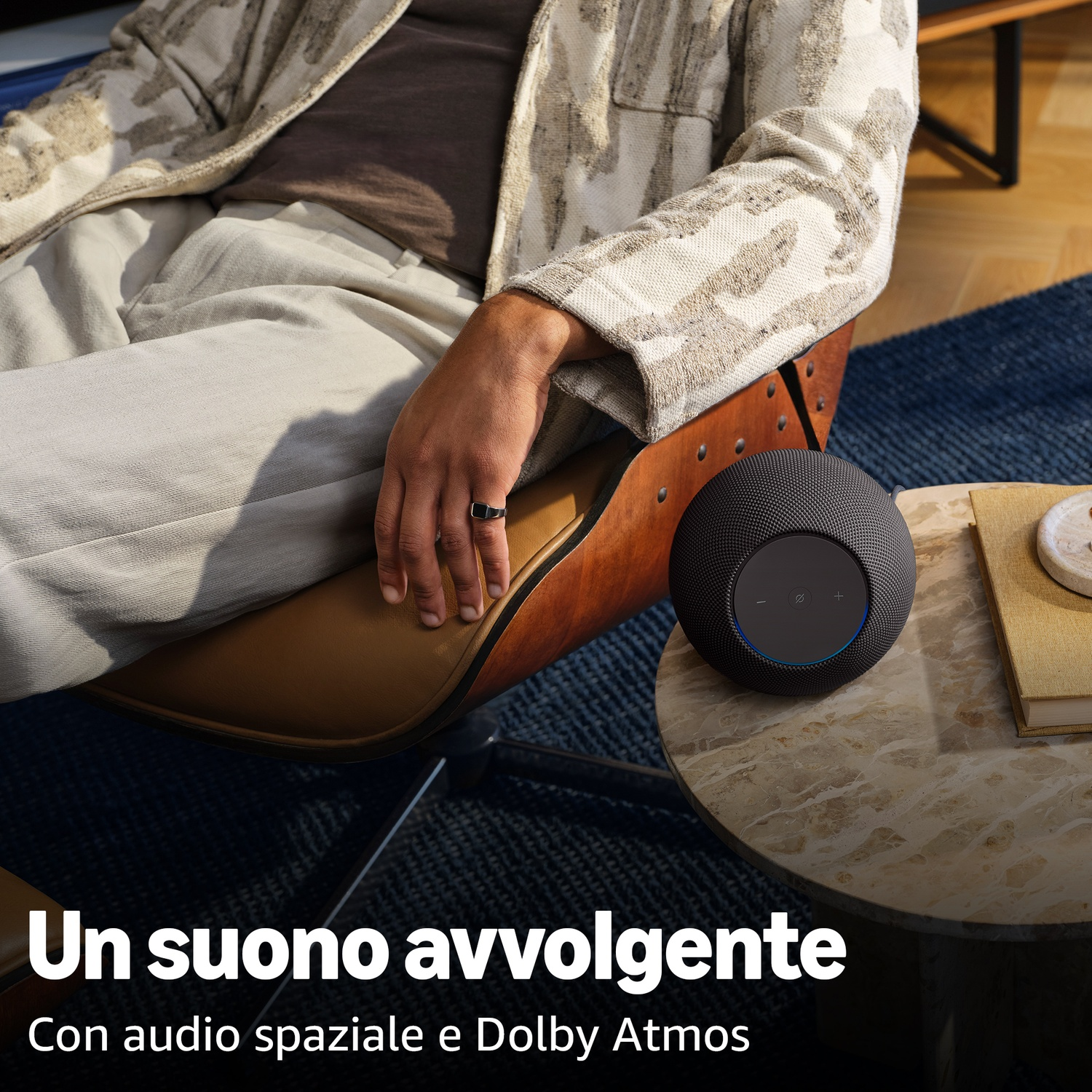 Una persona seduta su una sedia accanto a un altoparlante e un libro.