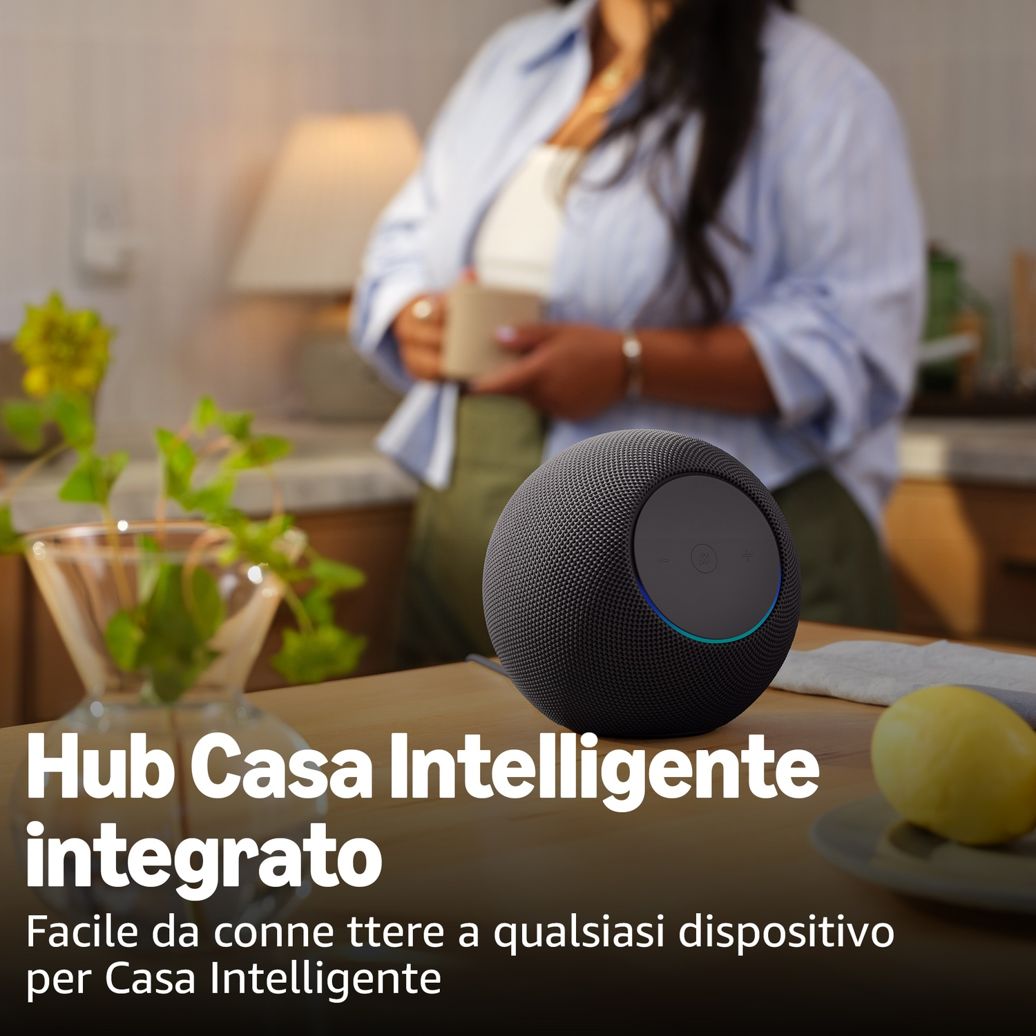 Uno smart speaker su un tavolo di legno con una donna sullo sfondo.