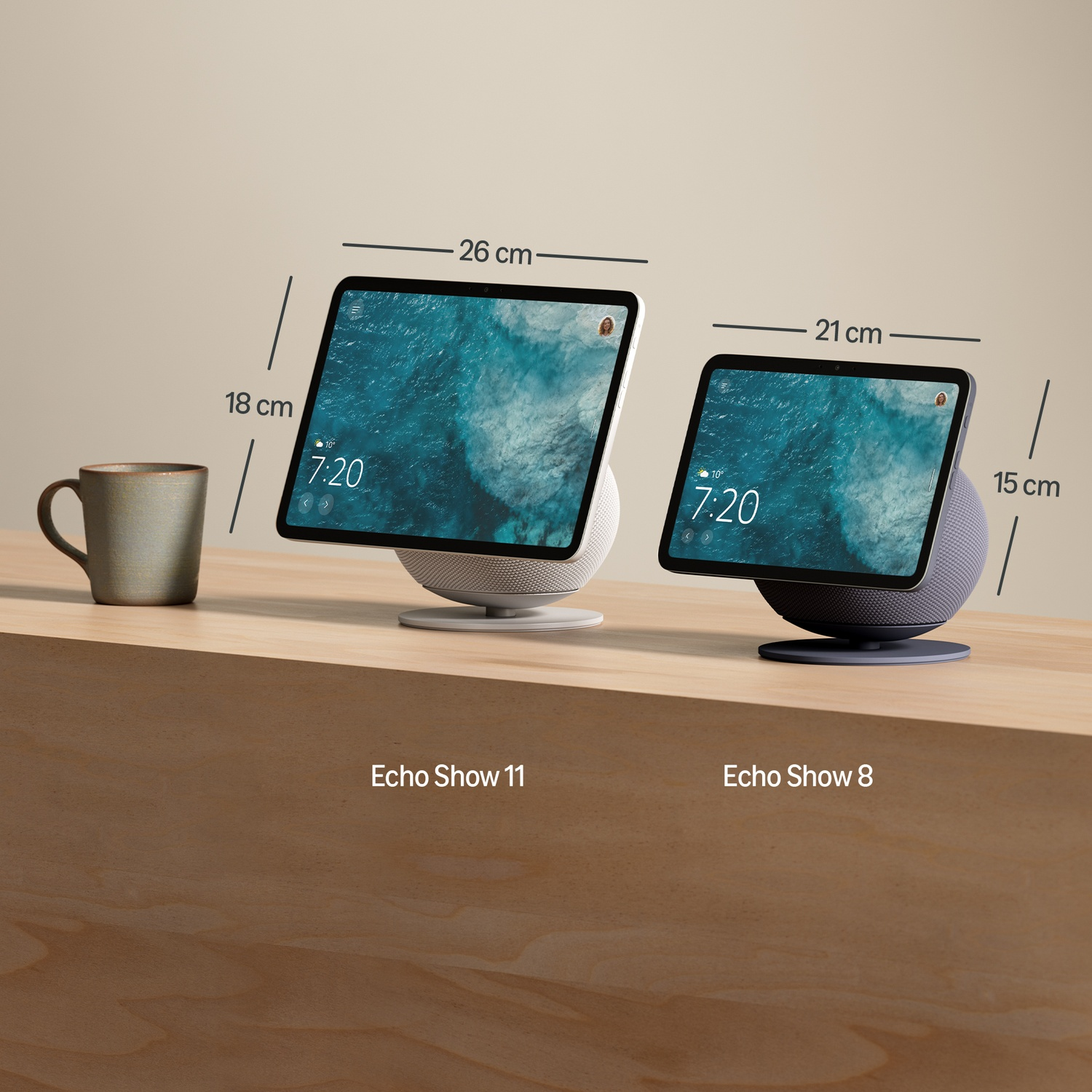 Due dispositivi Echo Show, uno 26x18cm, uno 21x15cm, accanto a una tazza.