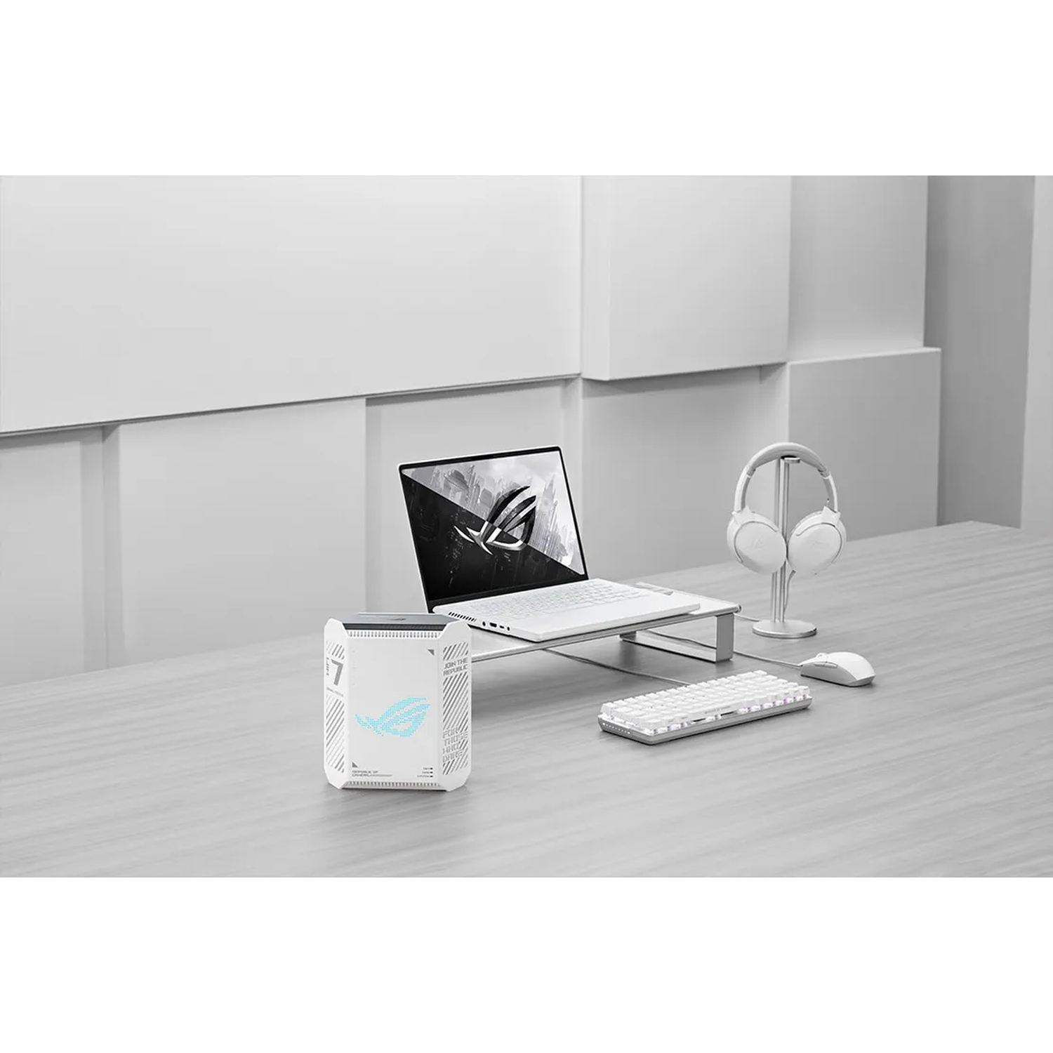 A white gaming PC, laptop, keyboard, mouse, and headphones on a desk.
