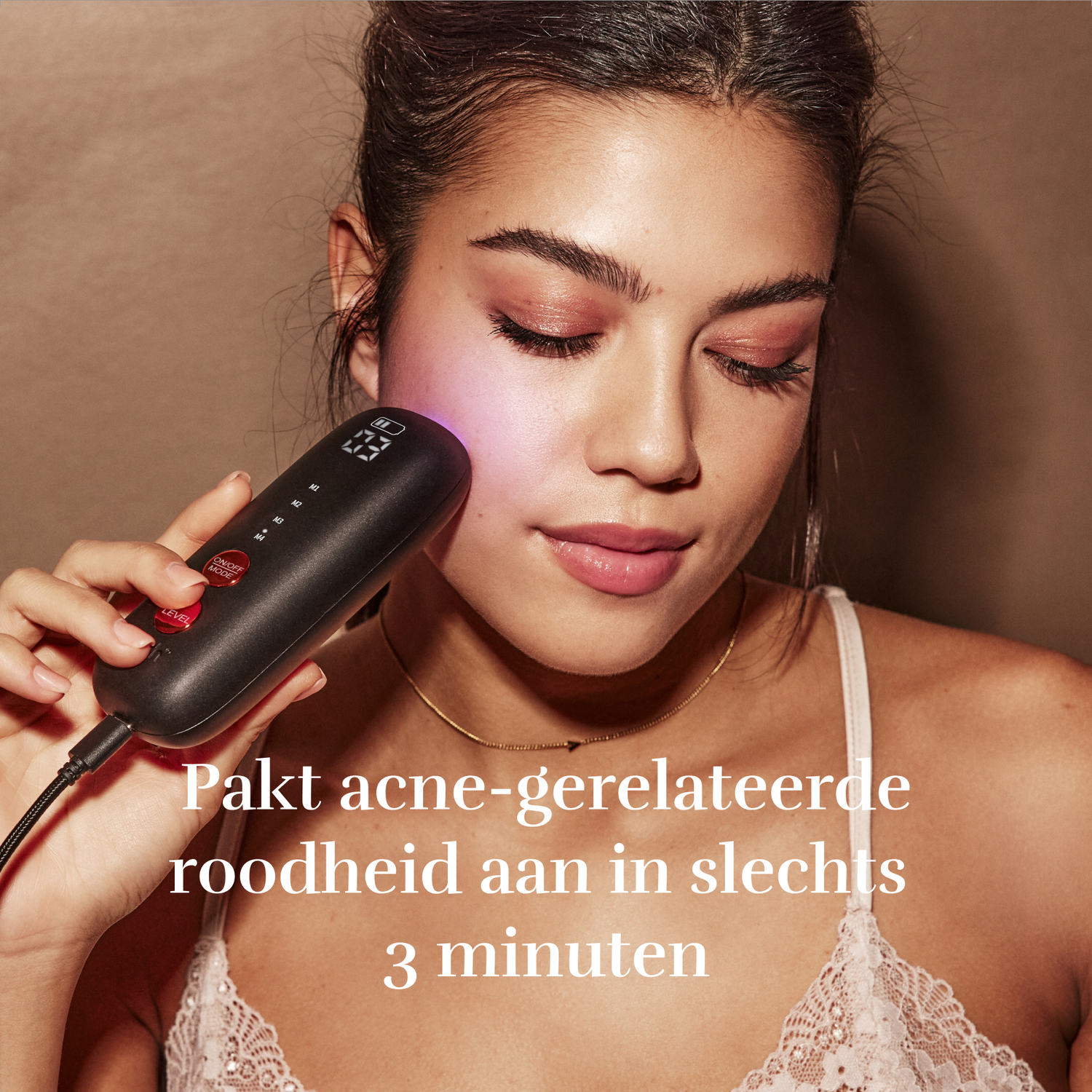 Een vrouw houdt een huidverzorgingsapparaat vast dat blauw licht afgeeft.