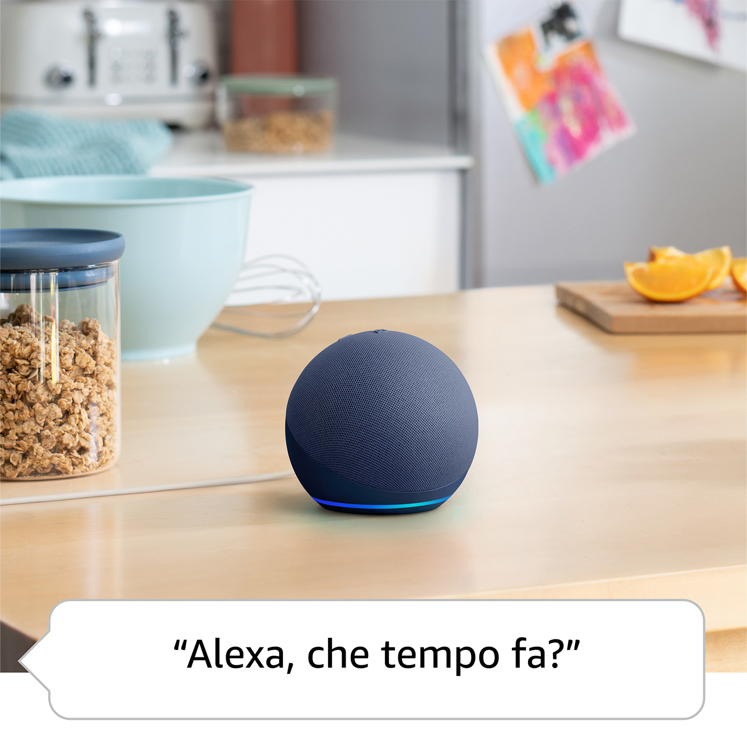 Un Echo Dot blu è su un tavolo di legno accanto a una ciotola e spicchi d'arancia.