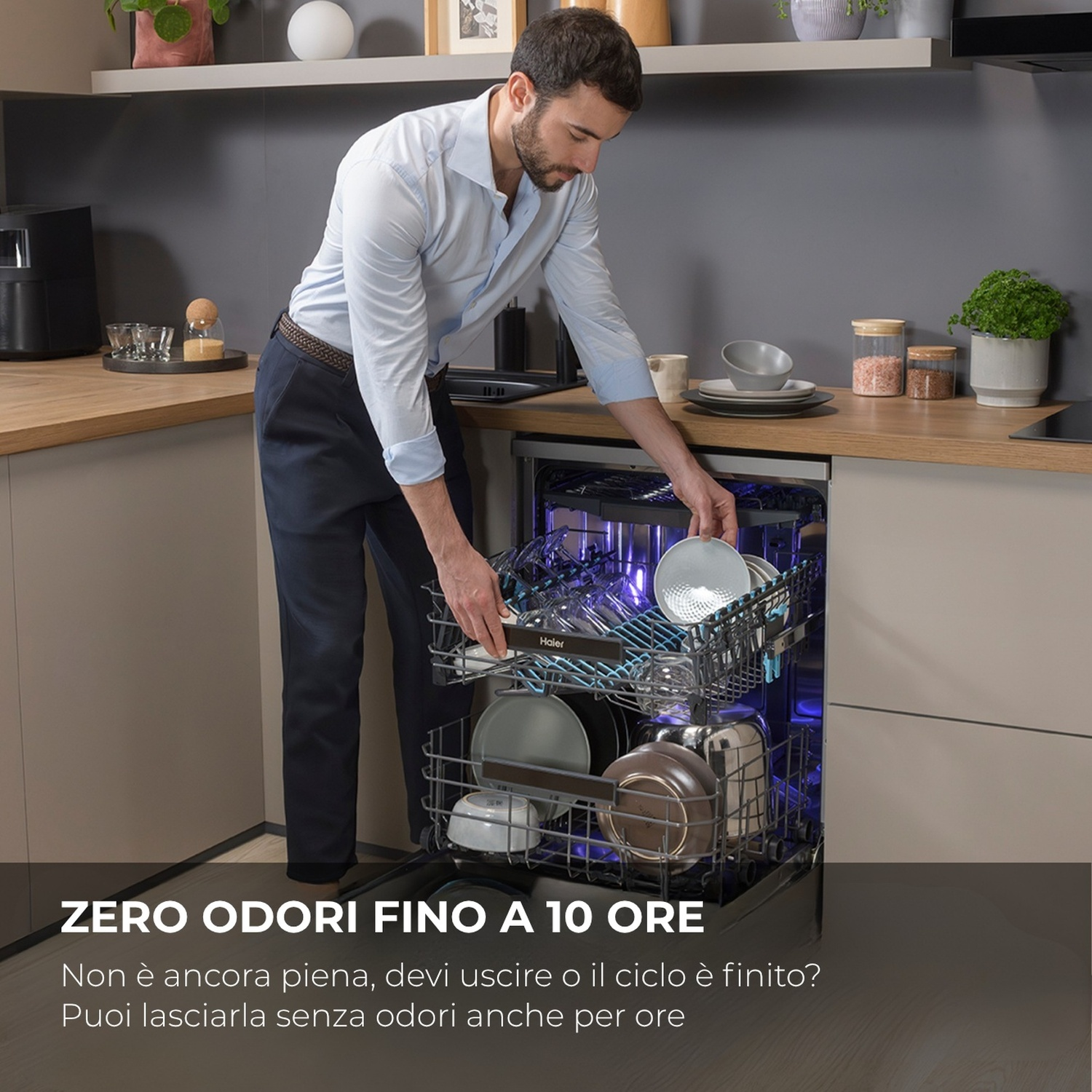 Uomo carica piatti in una lavastoviglie. Luci blu accese.