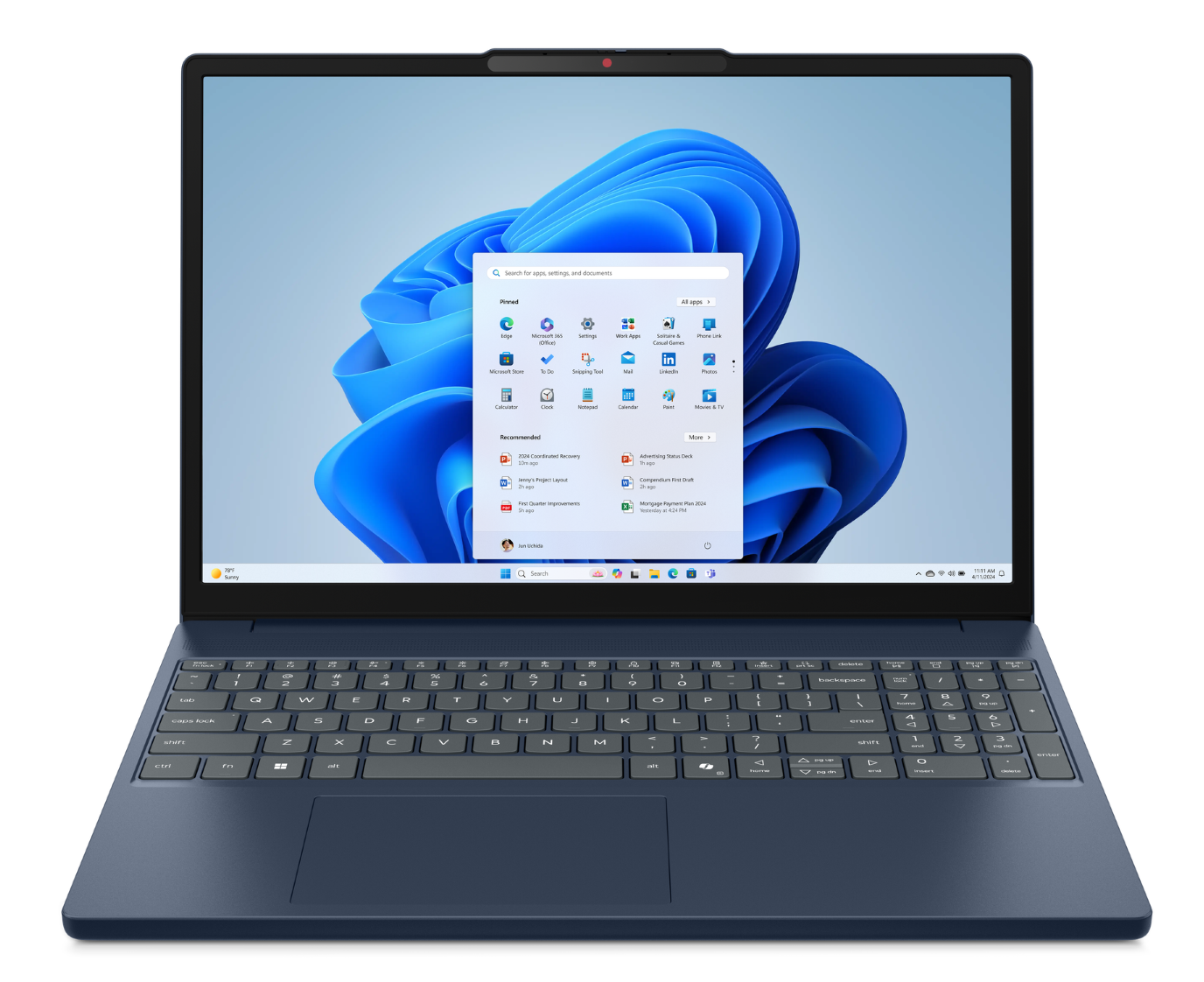 Ciemnoniebieski laptop z otwartym menu Start systemu Windows 11 na tle niebieskiej, falistej tapety.