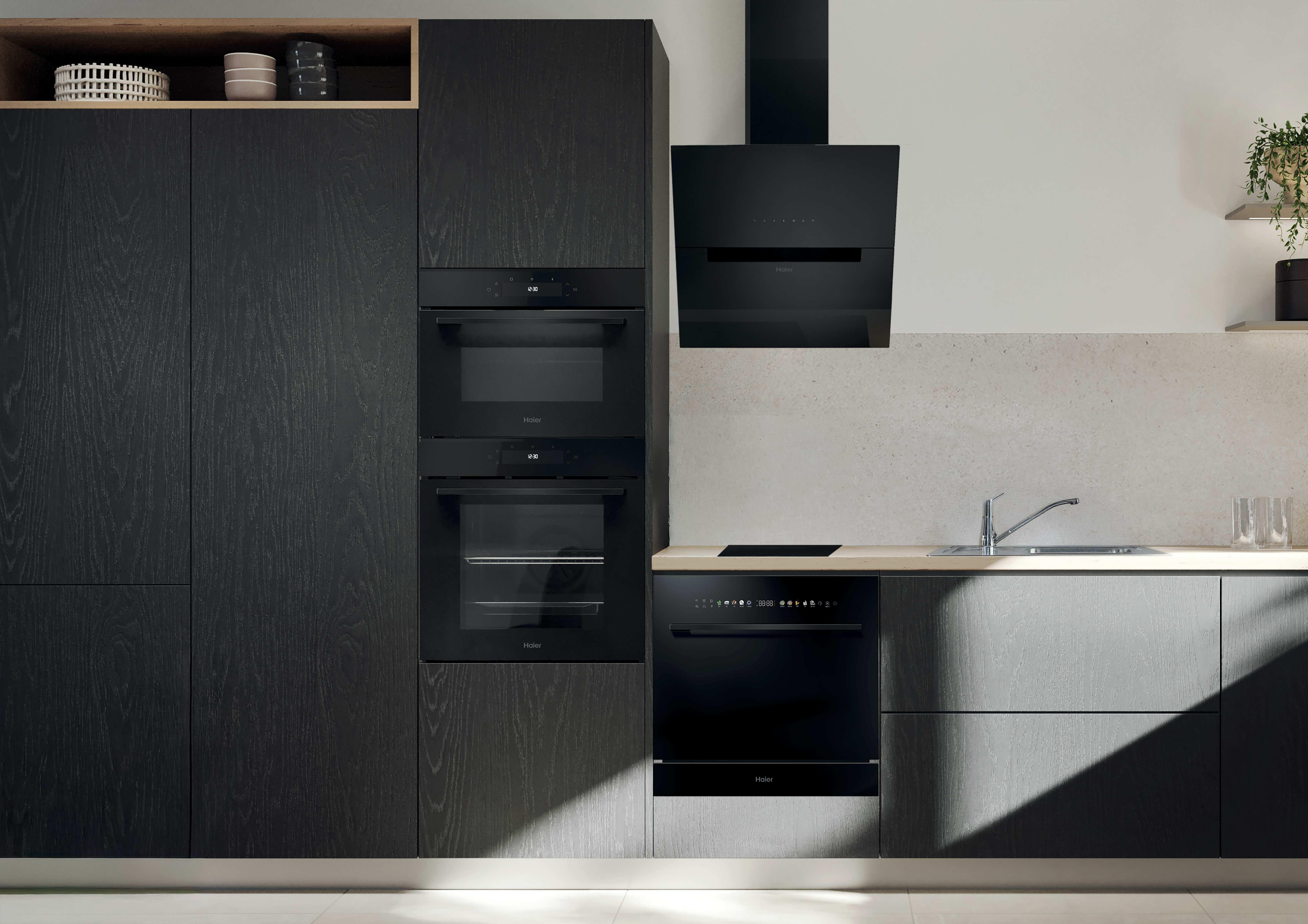 Moderne schwarze Küche mit eingebauten Haier-Geräten, Spüle und Kochfeld.