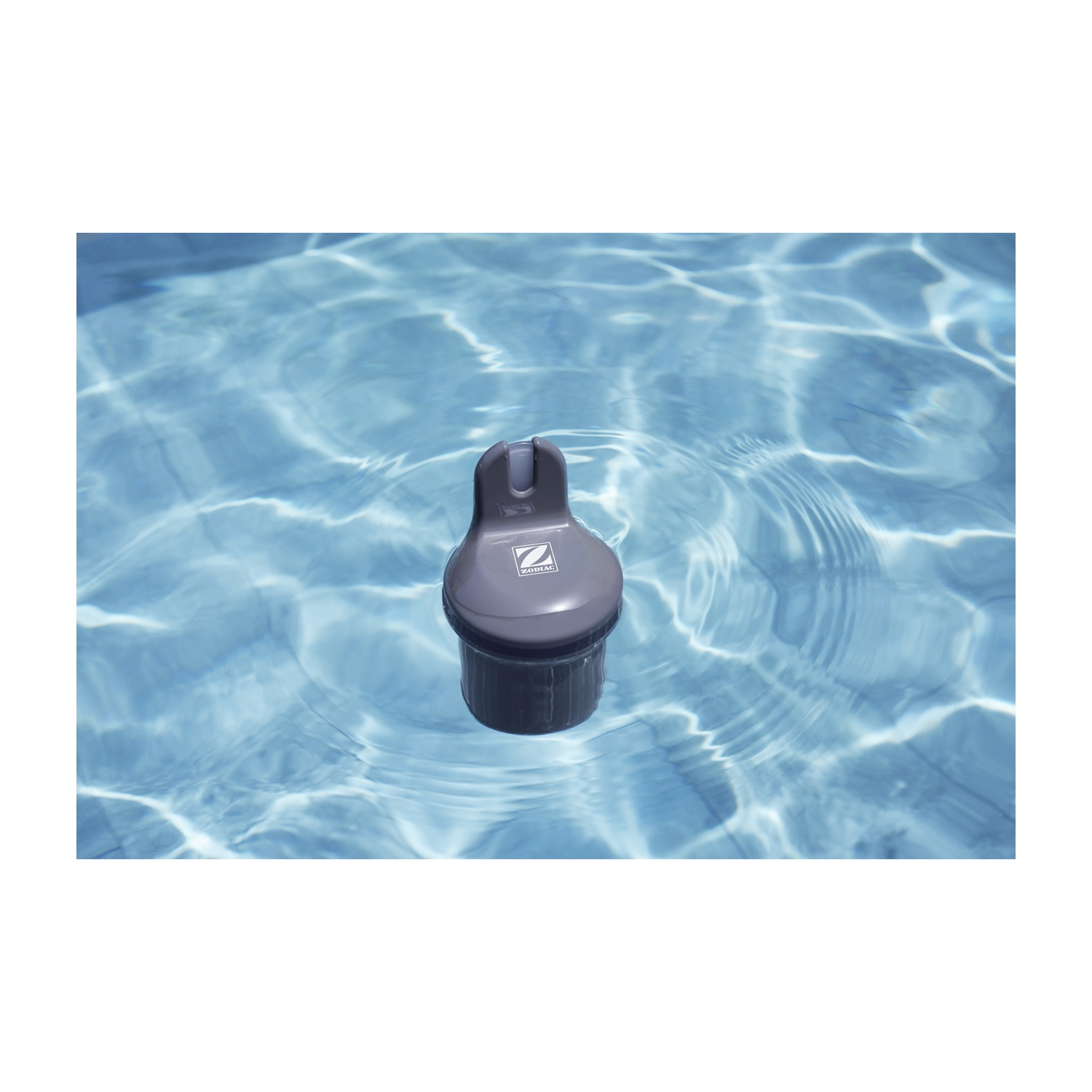 Uno skimmer per piscina grigio scuro con logo "Zodiac" galleggia sull'acqua blu.