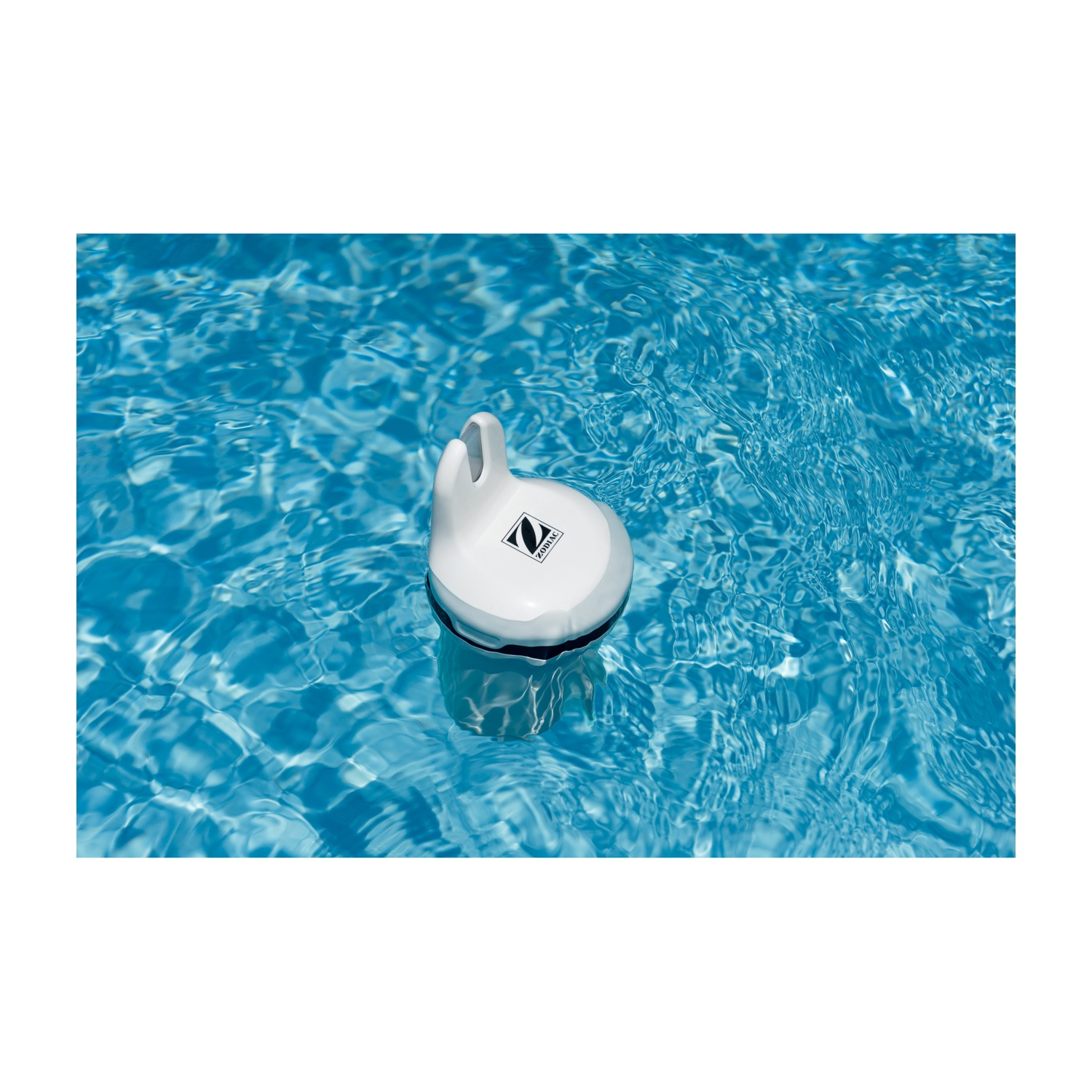 Un pulitore per piscina bianco galleggia sull'acqua blu.