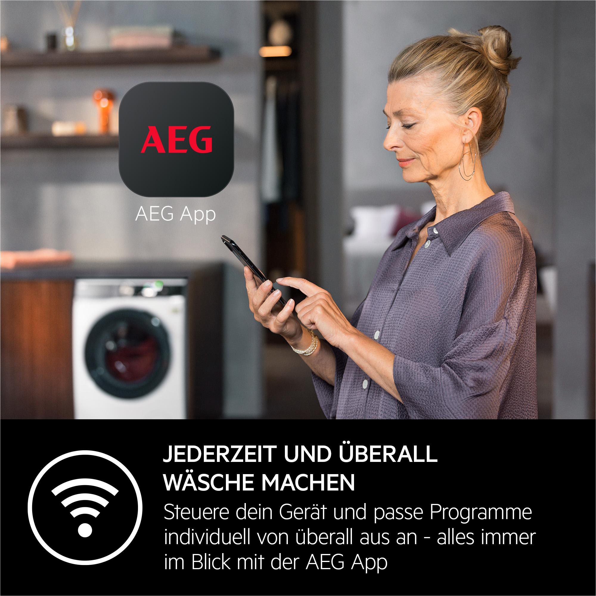 Frau bedient AEG App auf Smartphone vor Waschmaschine. Text: Wäsche machen.