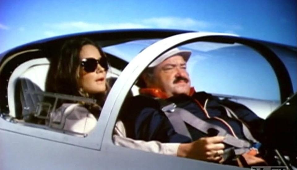 Mann und Frau in einem Flugzeugcockpit mit blauem Himmel.