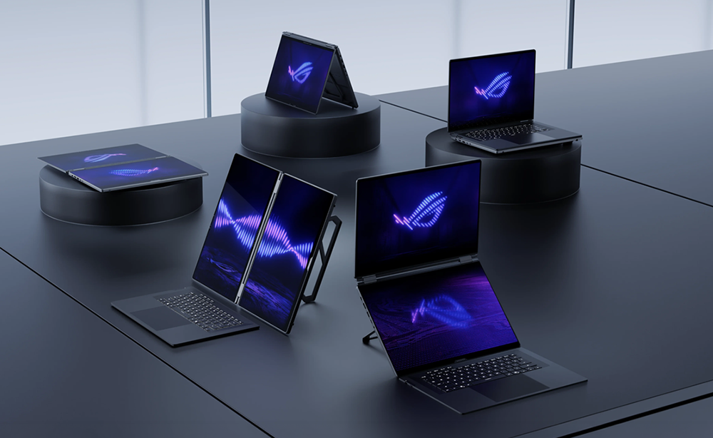 Mehrere schwarze Laptops mit leuchtend blauen und violetten Logos werden auf dunkler Oberfläche gezeigt.