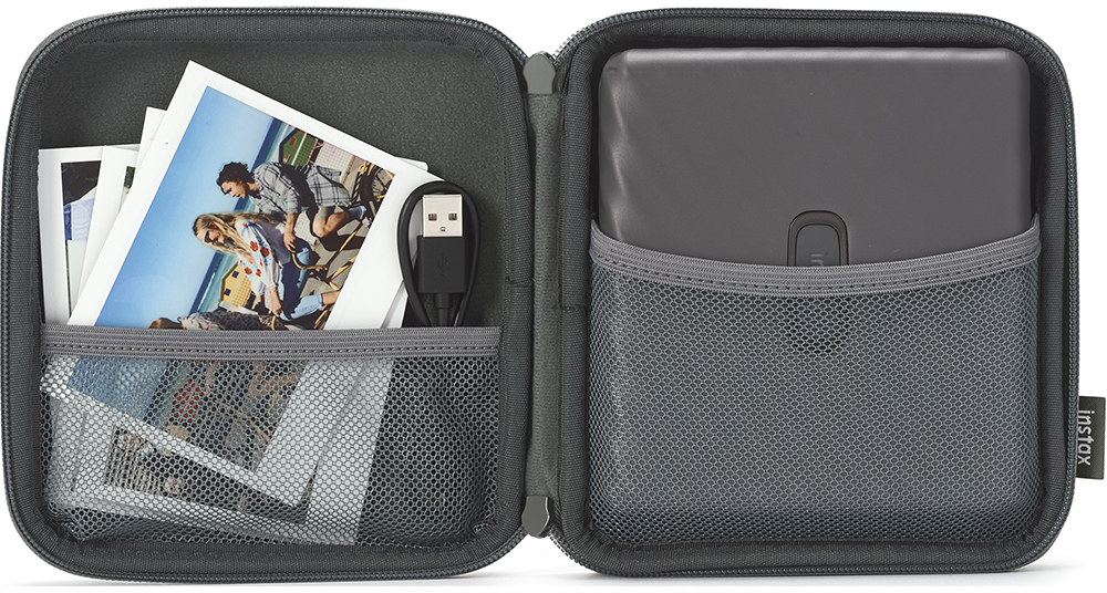 Szürke tok Instax nyomtatóval, fotókkal és USB kábellel.