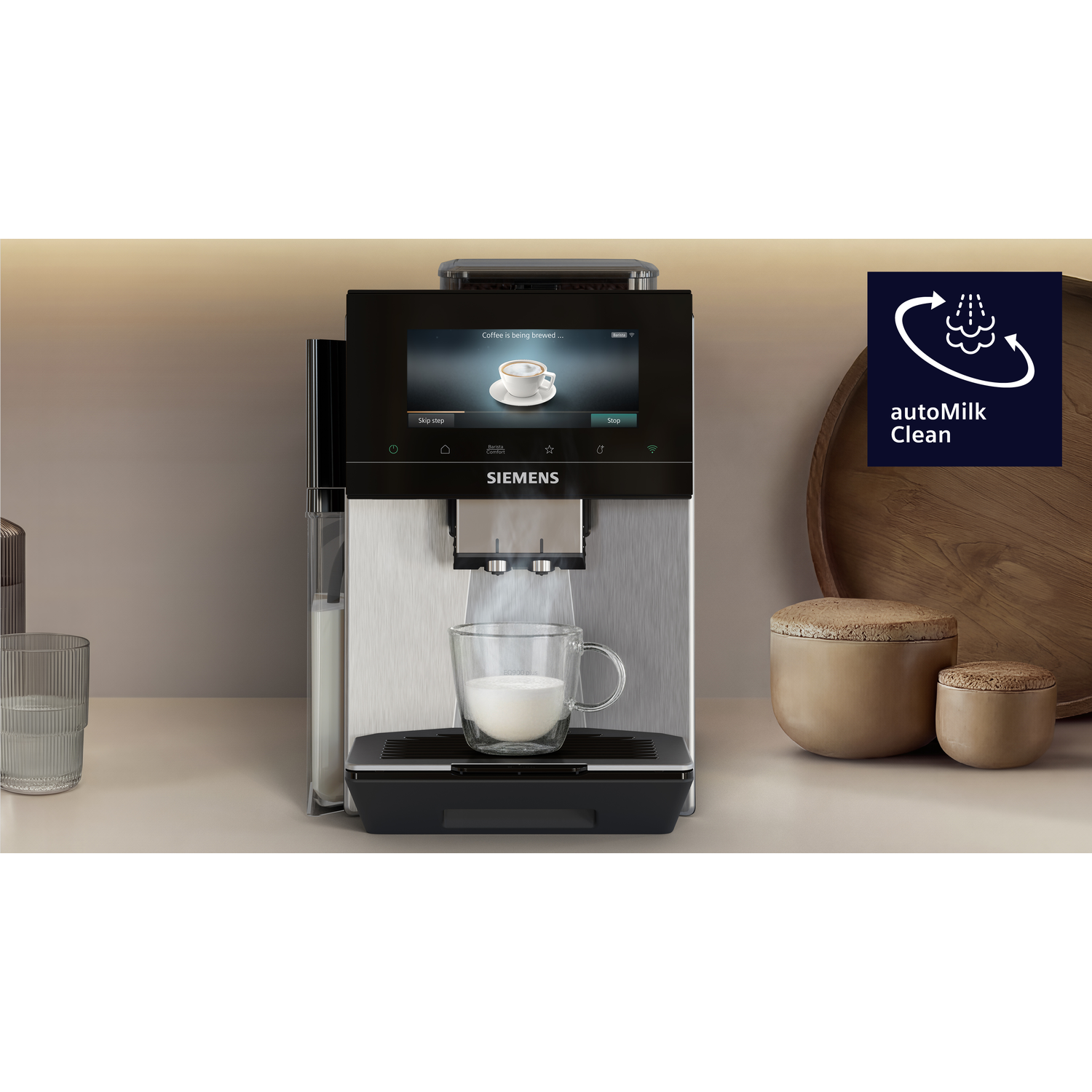 Machine à café avec récipient à lait, verre et deux boîtes.