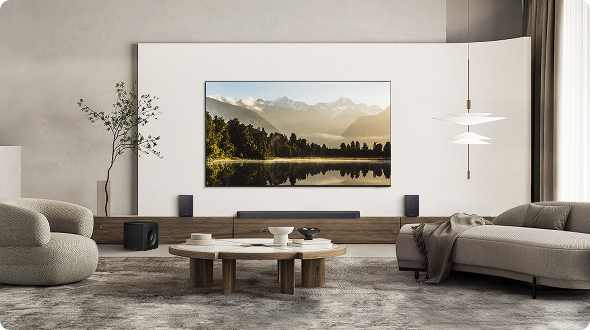 Ein Wohnzimmer mit Sofa, Couchtisch, Fernseher und Lautsprechern.