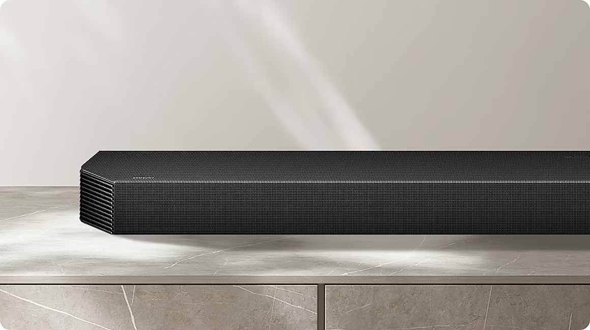 Schwarzer Samsung Soundbar mit gerillter Vorderseite auf Marmorplatte.