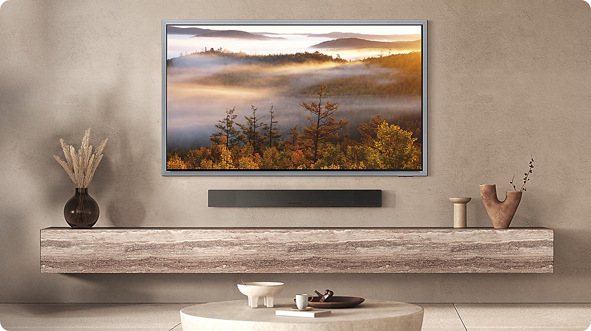 Un salon moderne avec une grande télévision affichant un paysage forestier brumeux.