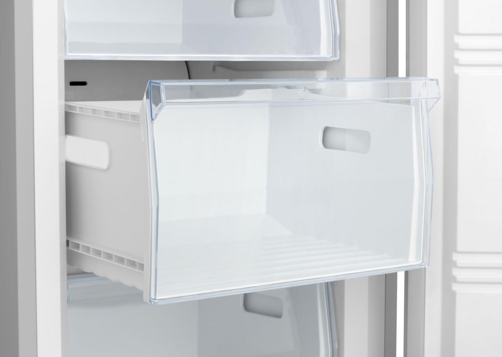 Eine transparente Schublade mit Griffen, die aus einem weißen Kühlschrank herausgezogen wird.