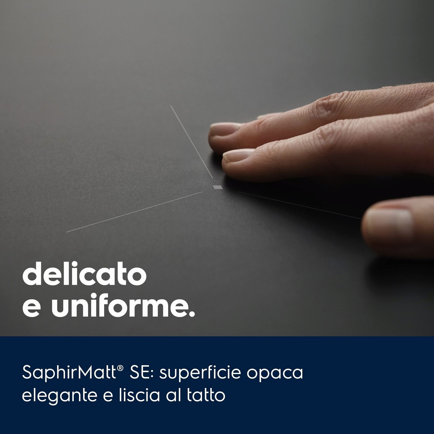 Una mano tocca una superficie scura e liscia con linee sottili.
