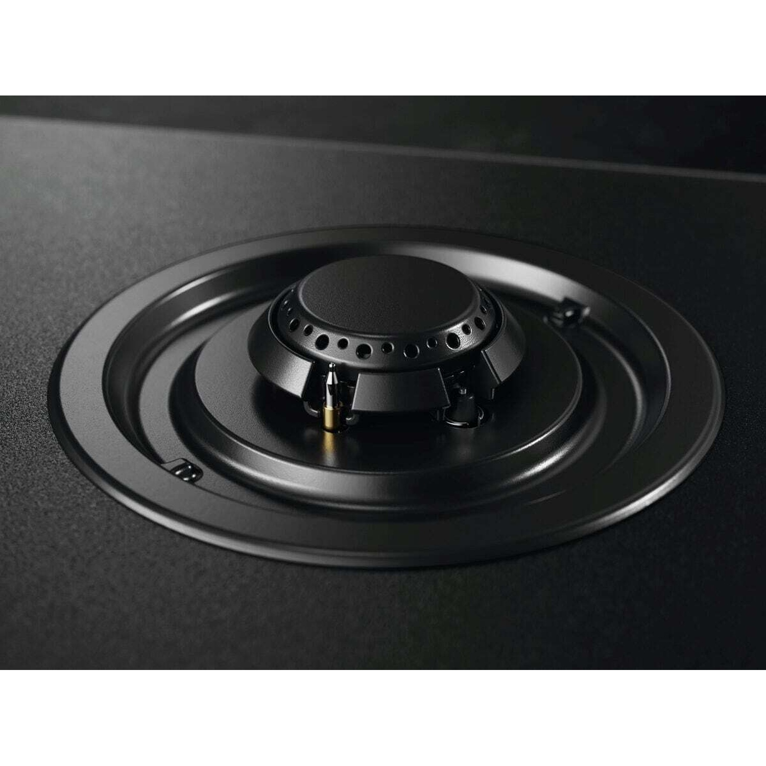 Bruciatore nero per piano cottura a gas su superficie nero opaco.