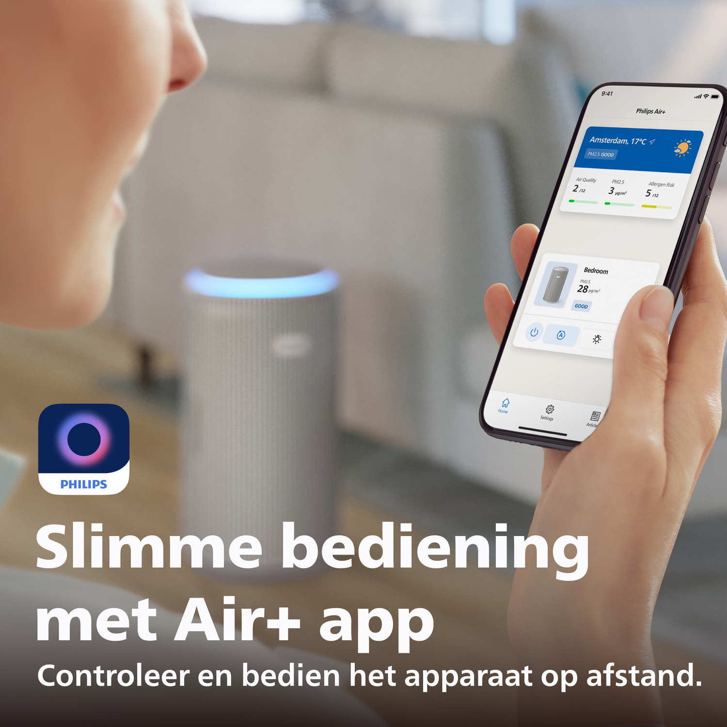 A person holds a smartphone with the Philips Air+ app. An air purifier is in the background.