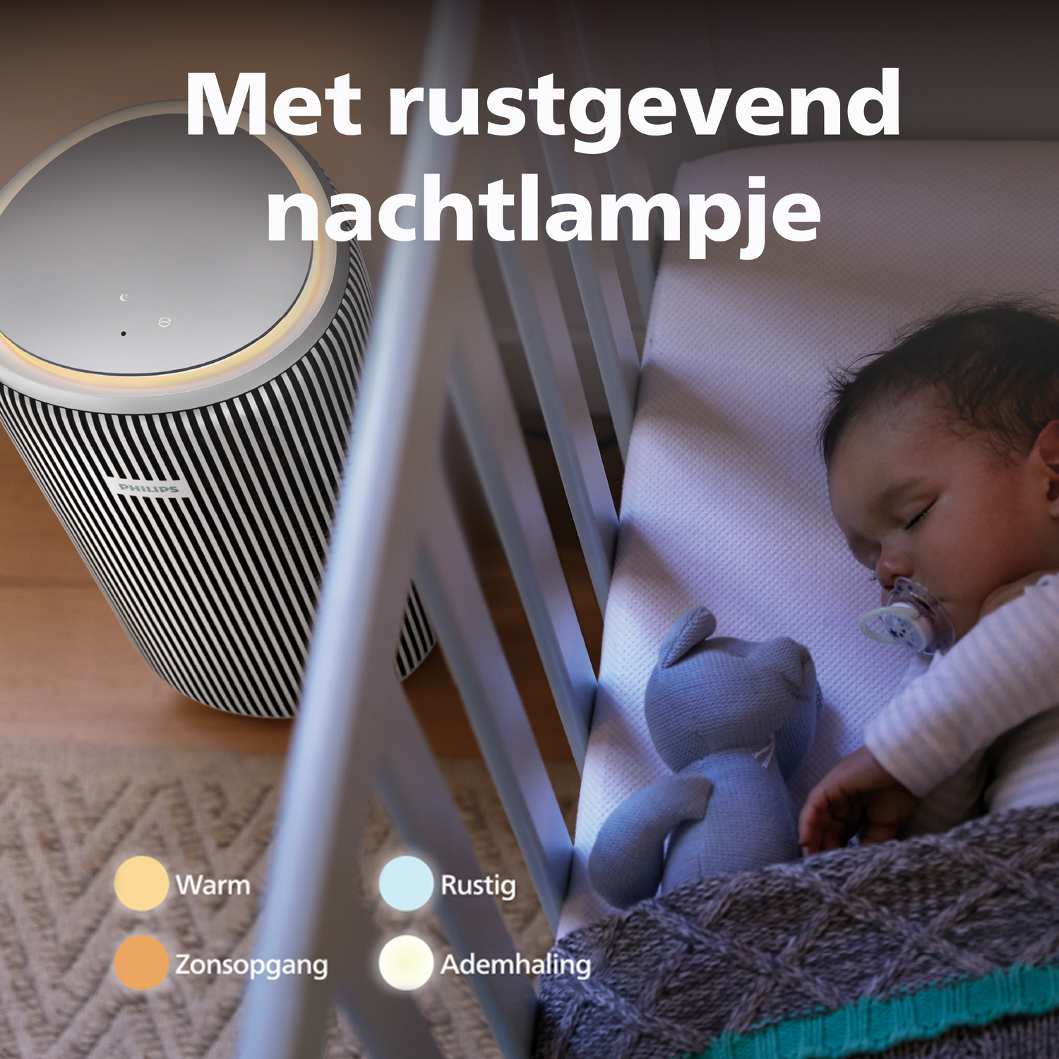 A baby sleeps in a crib next to a teddy bear and a nightstand.