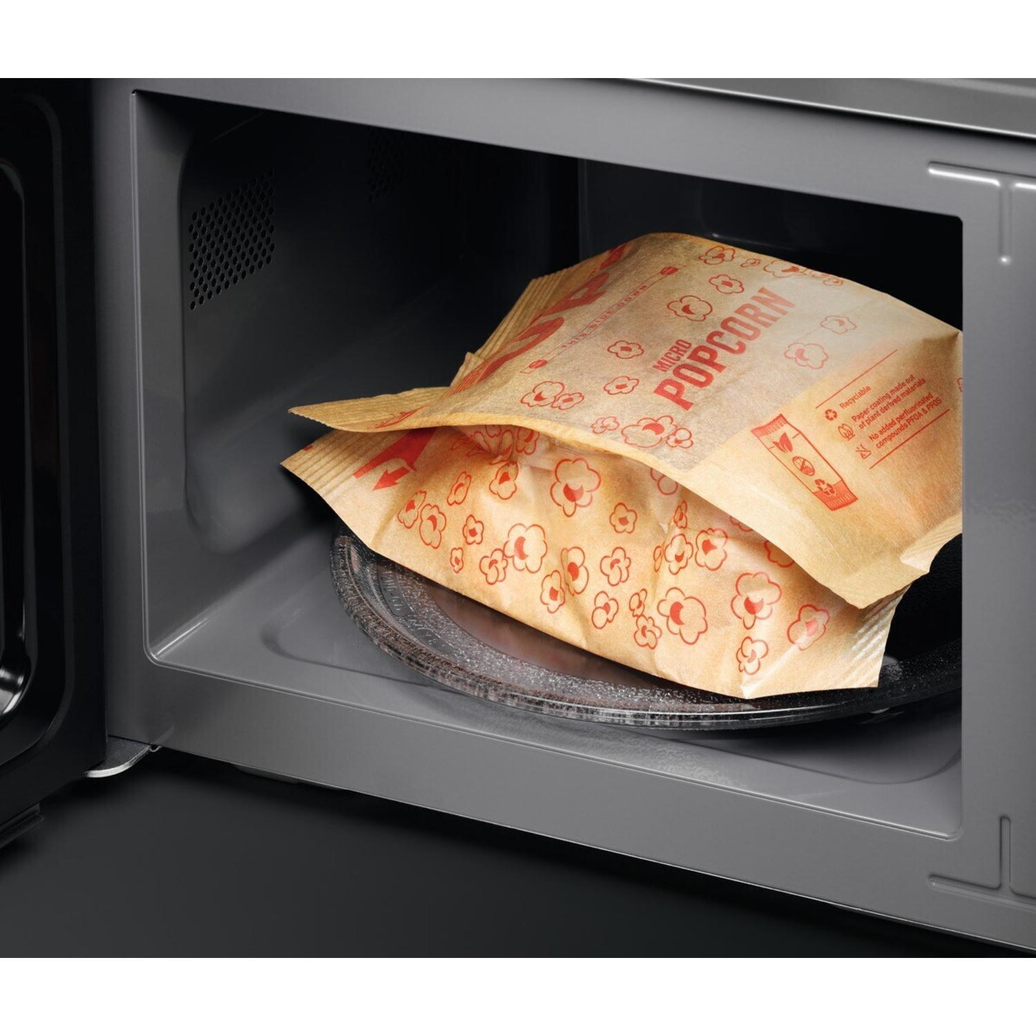 Due sacchetti di popcorn per microonde dentro un forno a microonde aperto.