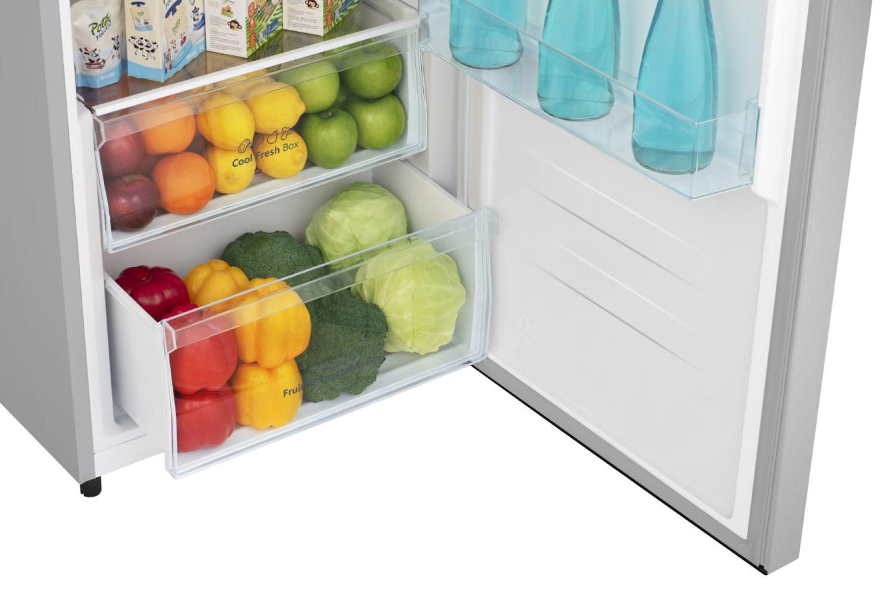 Ein Kühlschrank mit Obst und Gemüse in den Schubladen und blauen Flaschen.