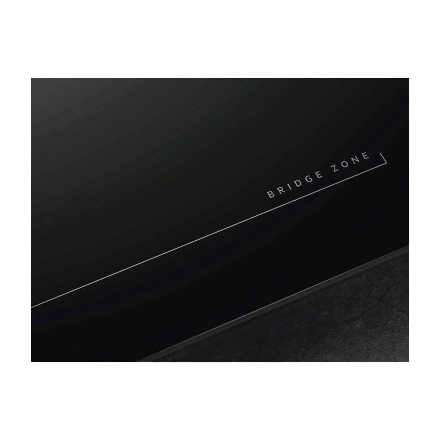 Piano cottura nero con scritta 'BRIDGE ZONE' e una sottile linea bianca.