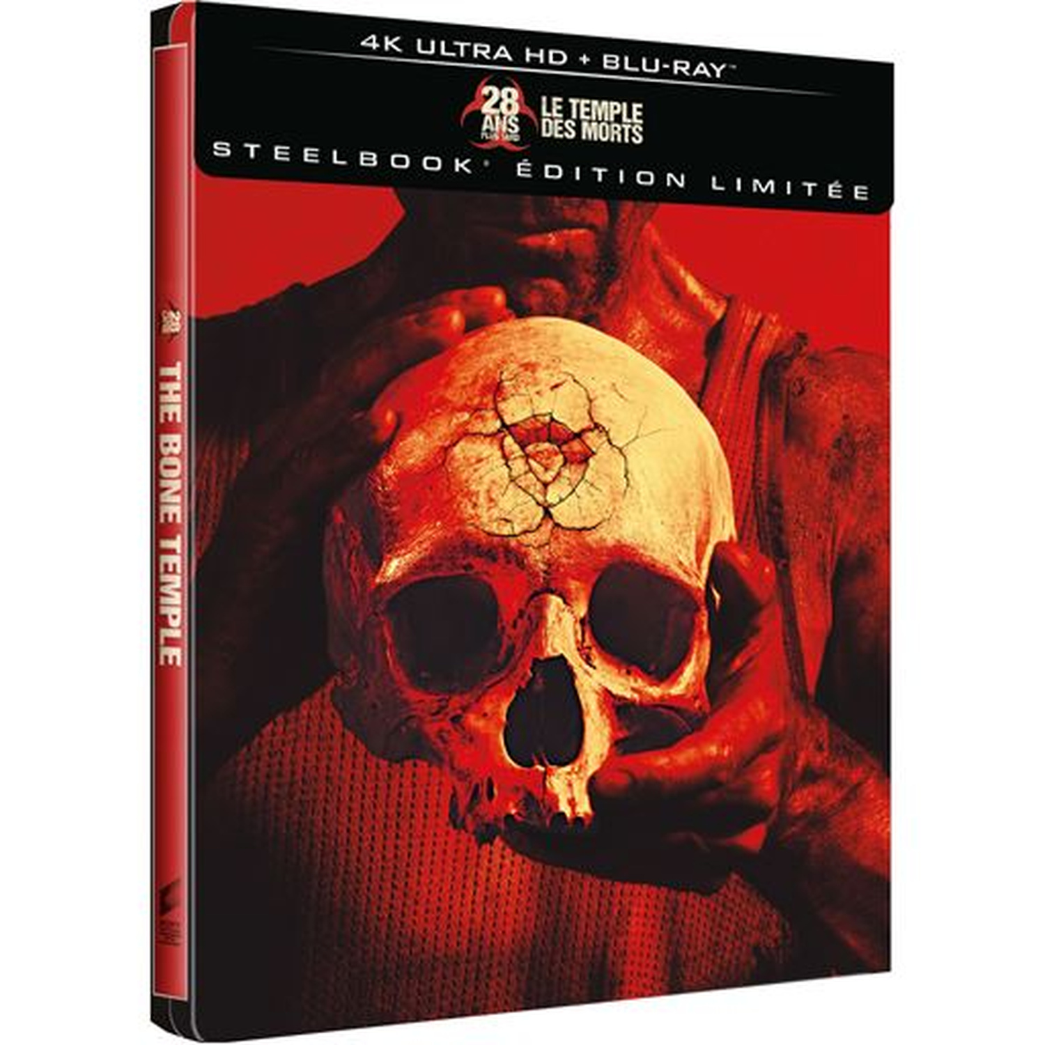 Een man houdt een gebarsten schedel vast tegen rode achtergrond. Steelbook editie.
