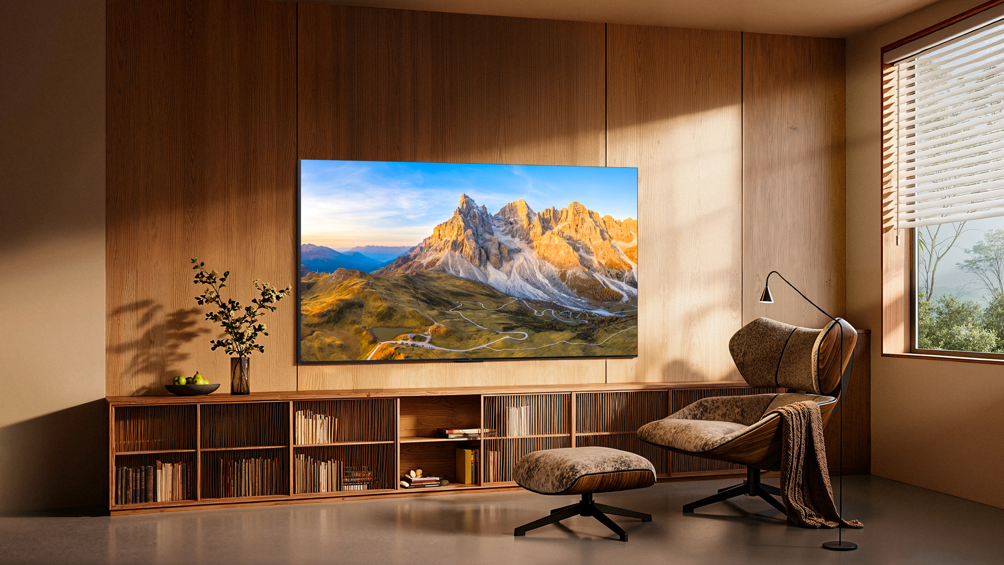 Modernes Wohnzimmer mit TV, Berglandschaft, Sessel, Hocker und Holzschrank.