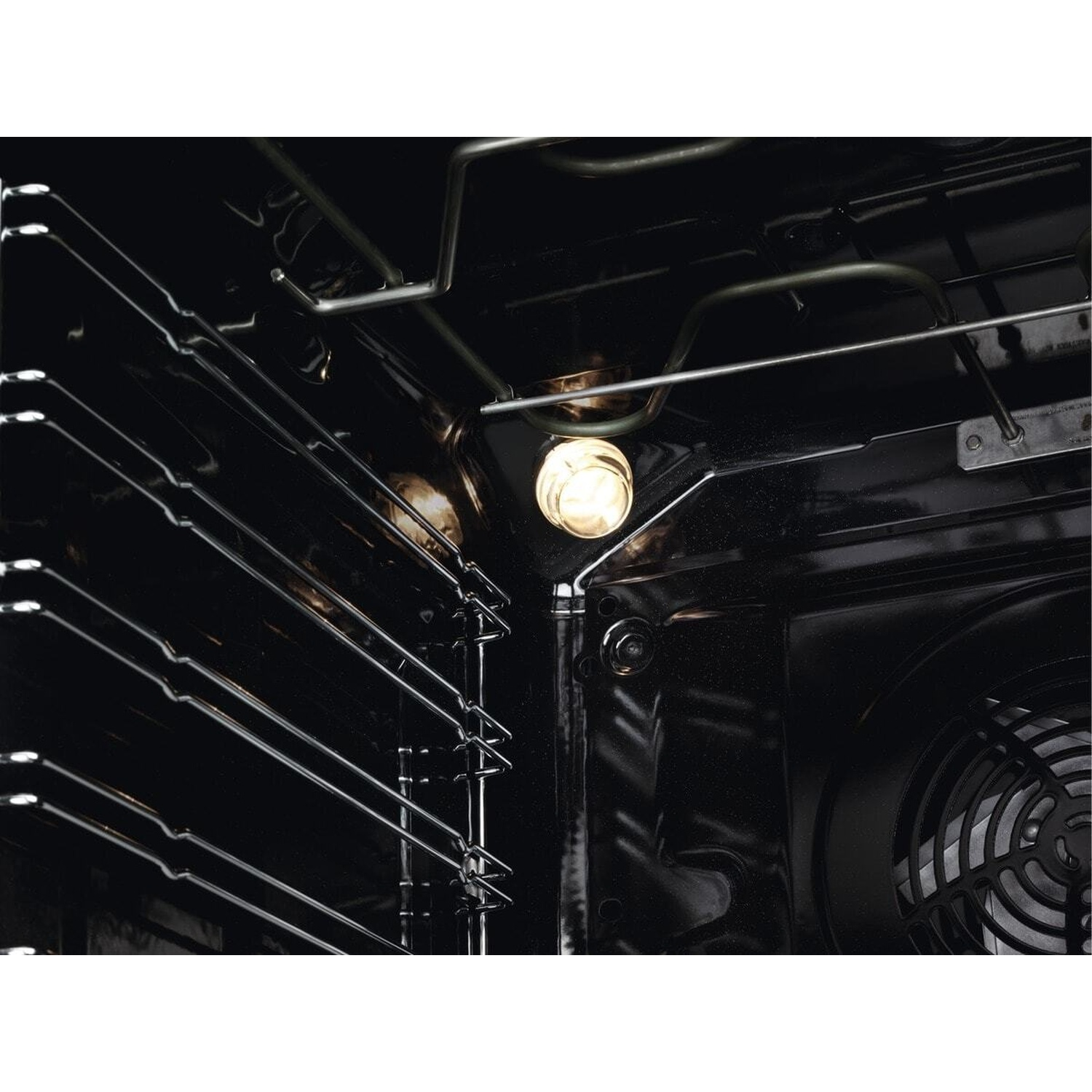 Interno di un forno con luce, griglie e ventola.